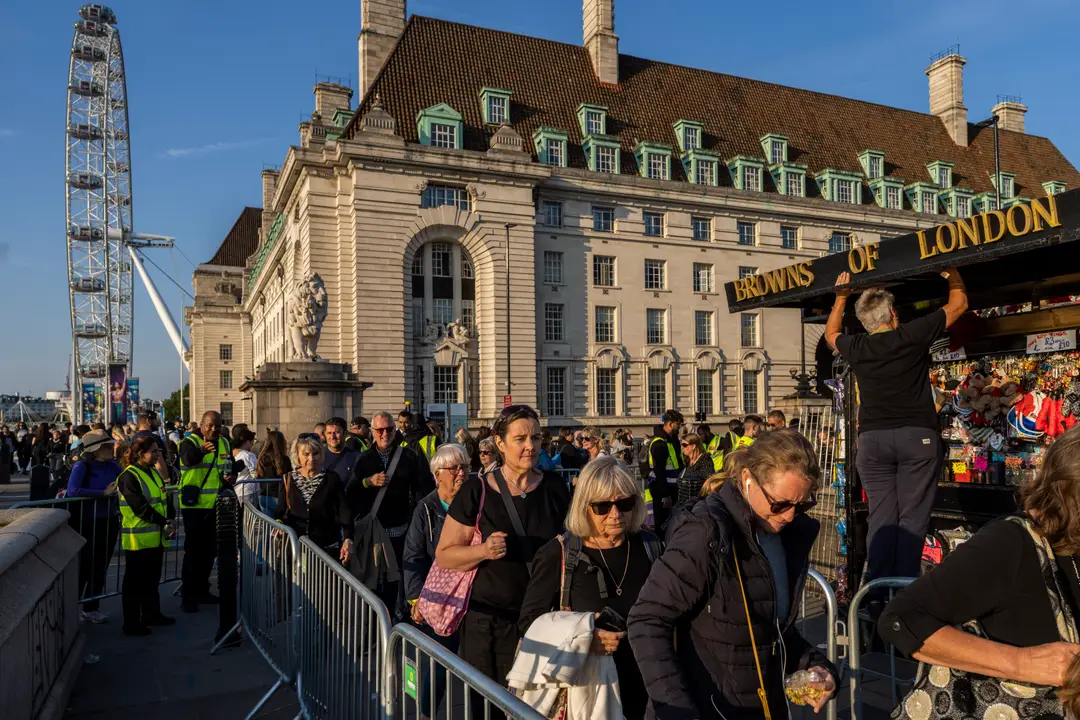 Ľudia, ktorí sa prišli naposledy rozlúčiť so zosnulou britskou kráľovnou Alžbetou II., stoja v rade pred sídlom parlamentu.