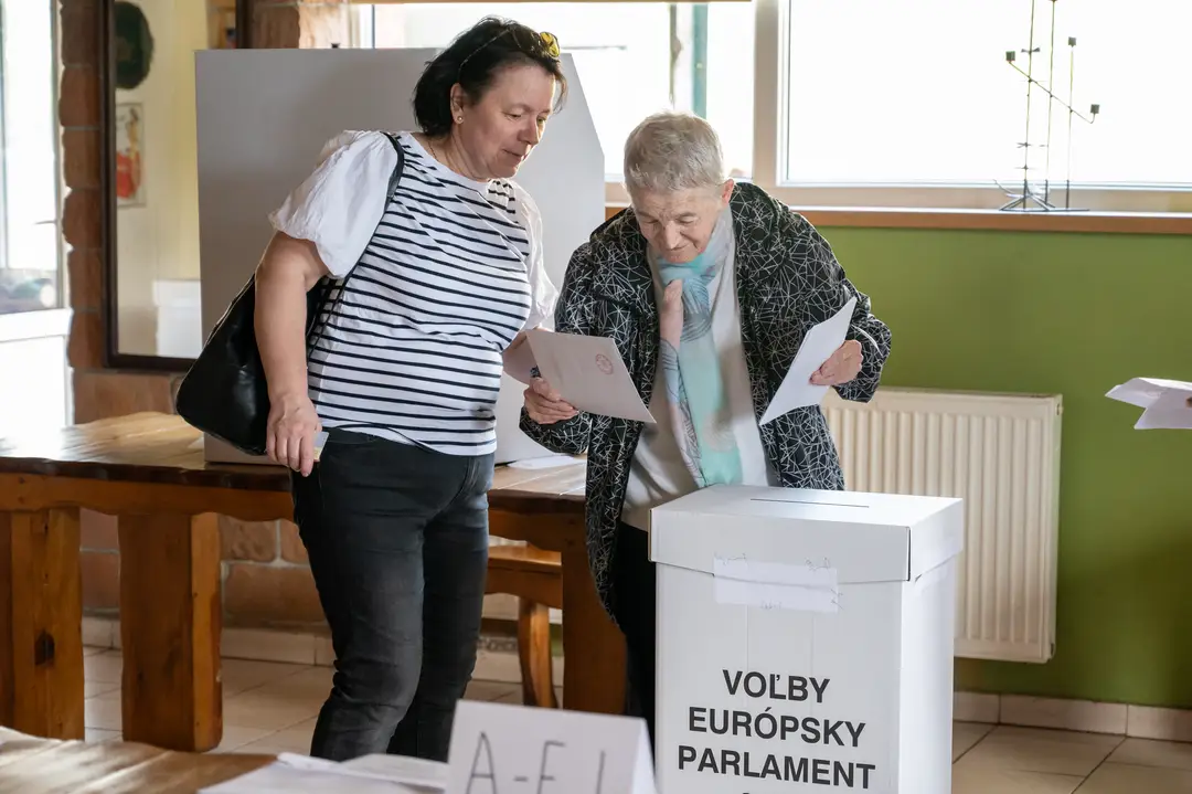 Na snímke volička s doprovodom vhadzuje obálku s hlasovacím lístkom do volebnej schránky v Prešove.