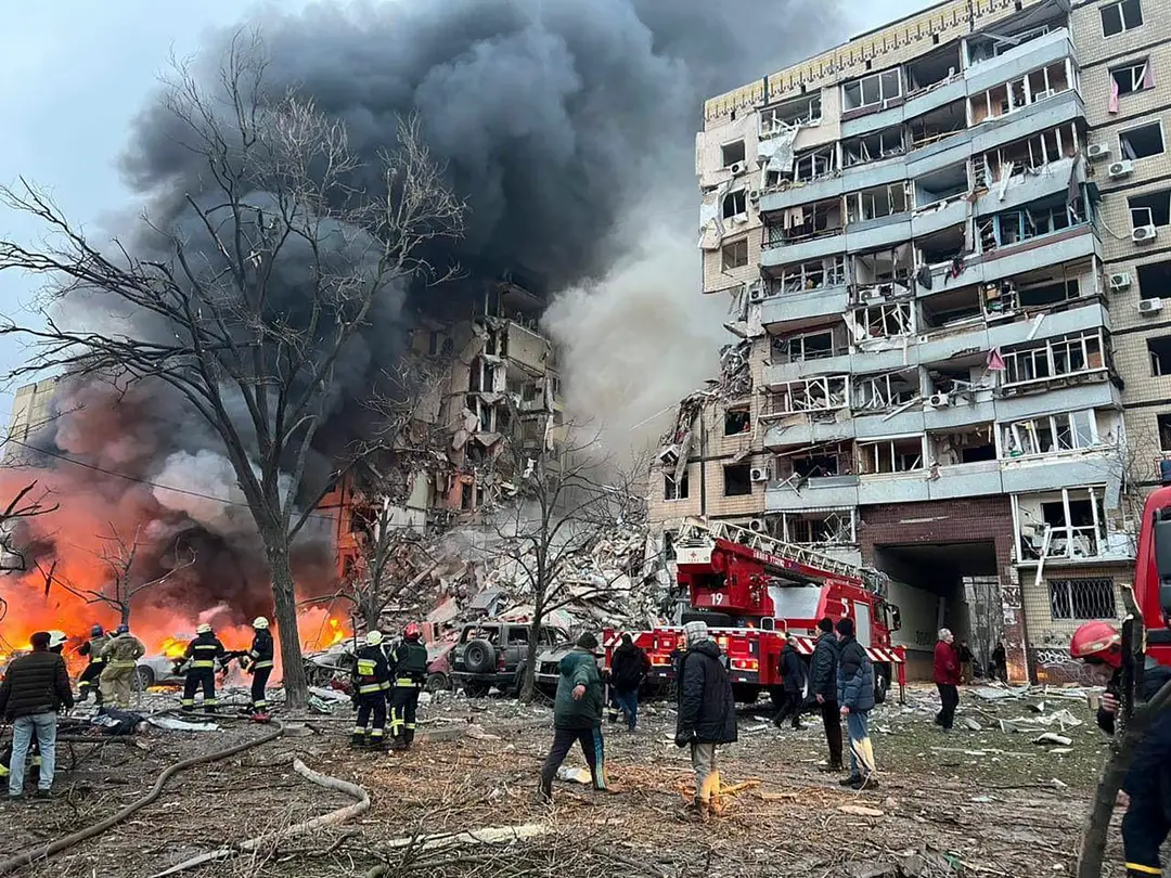 Čierny hustý dym stúpa k oblohe po raketovom útoku ruskej armády na výškovú obytnú budovu v Dnipre, kde pod troskami zostalo mnoho ľudí.