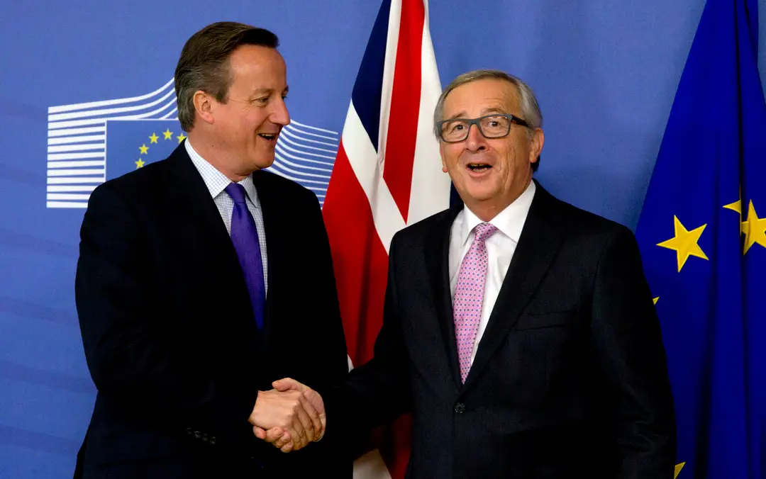 Britský premiér David Cameron si podáva ruku a predseda Európskej komisie Jean-Claude Juncker