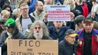 Protestujúci s protivládnymi transparentami
