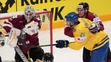 Švéd Jimmie Ericsson v súboji s lotyšským brankárom Elvisom Merzlikinsom a jeho spoluhráčom Guntisom Galvinsom počas duelu MS v 