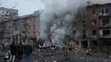 Ľudia si prezerajú materiálne škody na obytnej budove po ruskom raketovom útoku v Kyjeve.