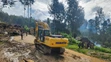 Dedinčania ťažkým mechanizmom prehľadávajú oblasť postihnutú zosuvom pôdy v dedine Yambali.