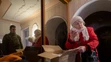 Galina Ivanovna odovzdáva Ivanovi materiál vyzberaný od dobrovoľníkov