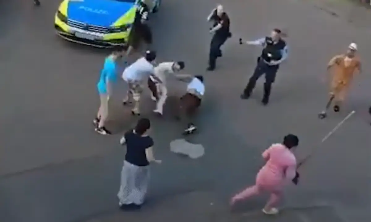Policajti sa prizerajú na bitku klanov.