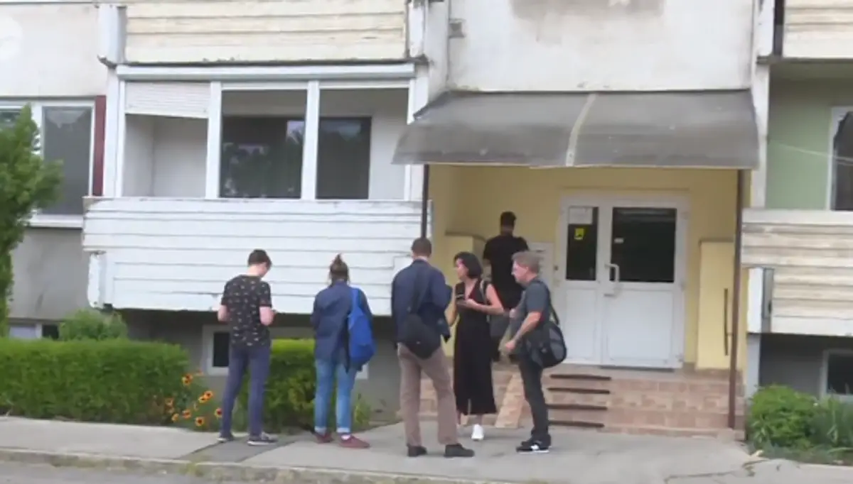 Na snímke ľudia pred bytovkou v Leviciach, kde býva atentátnik.