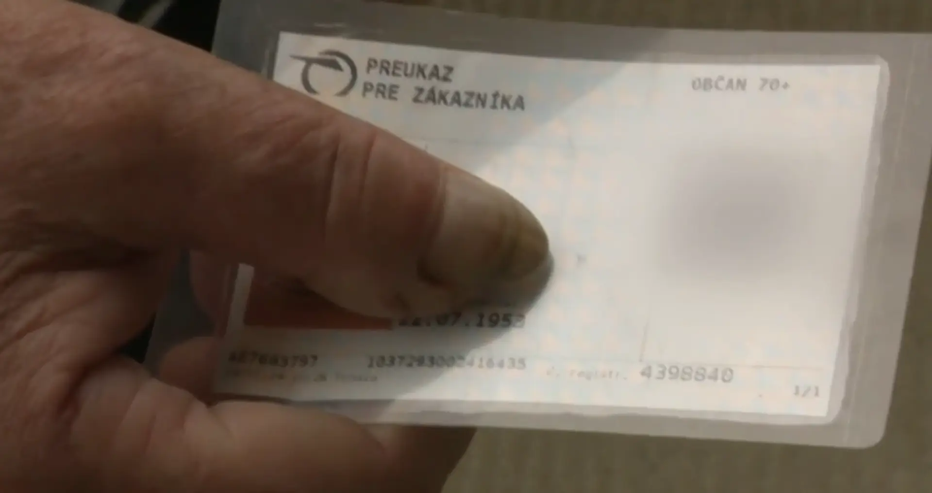 Na sníme muž drží v ruke plastovú zľavovú kartu na vlak.