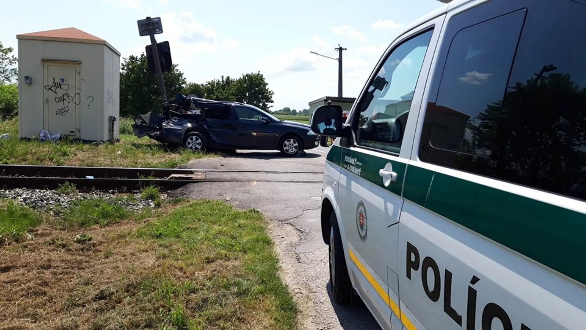 Polícia na mieste nehody osobného auta a vlaku.