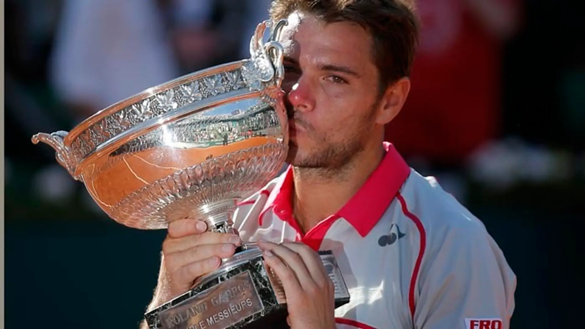 Švajčiar Stan Wawrinka bozkáva trofej po víťazstve proti Srbovi Novakovi Djokovičovi vo finále mužskej dvojhry na grandslamovom 