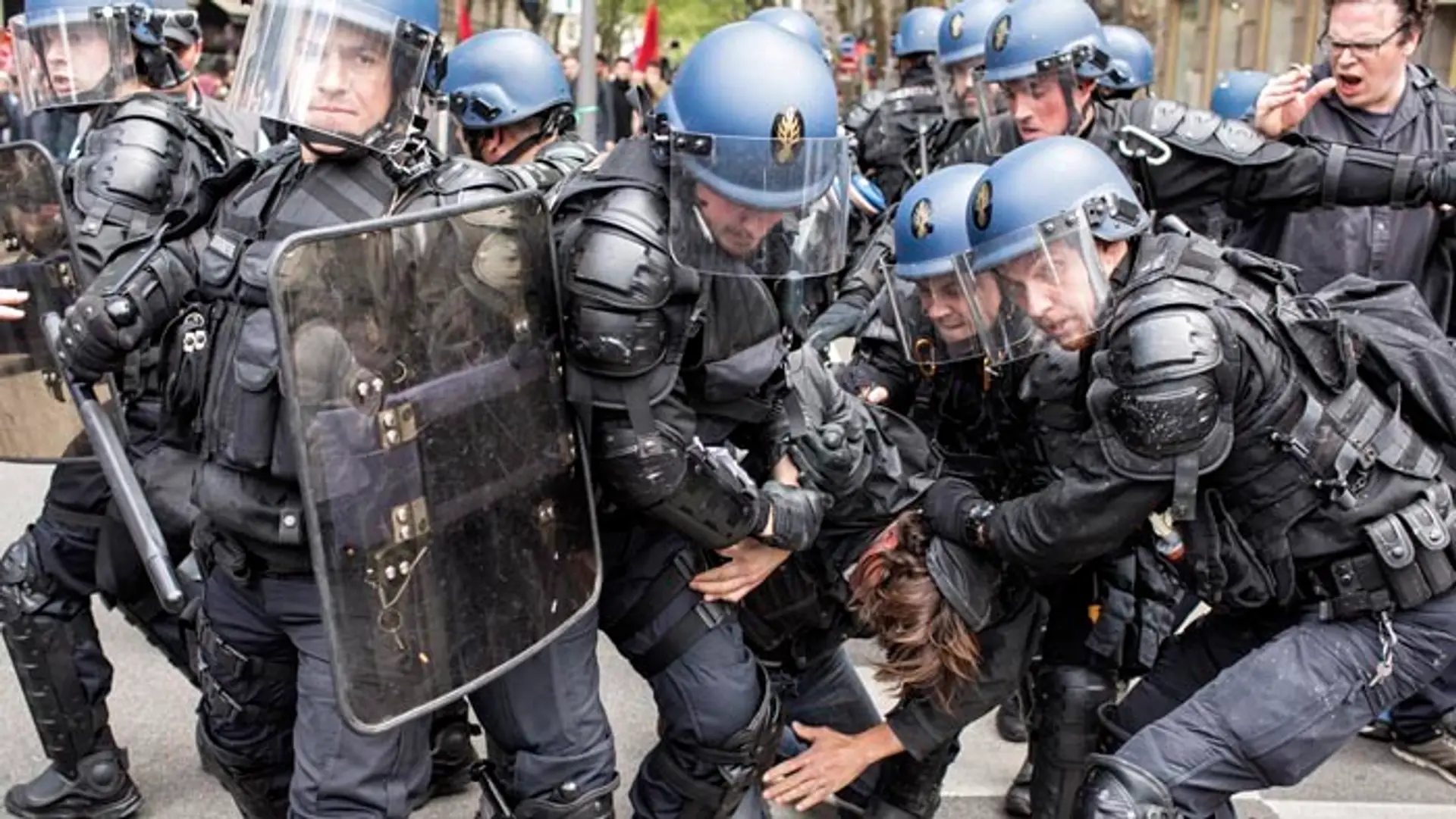 Poriadková polícia odvádza zadržaného demonštranta počas protestu proti plánovaným reformám.