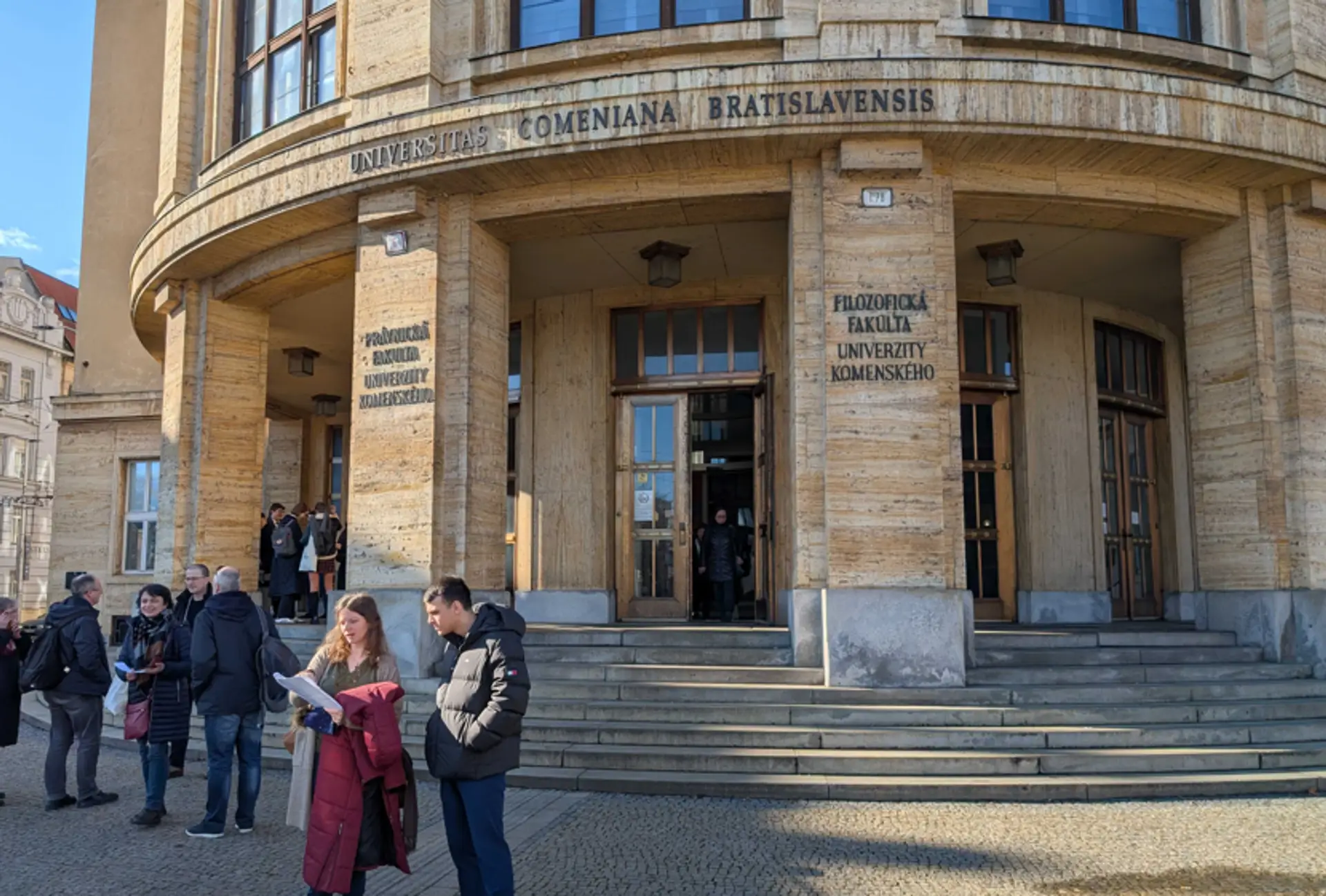 Študenti pred Univerzitou Komenského v Bratislave, ktorú evakuovali pre bombovú hrozbu.