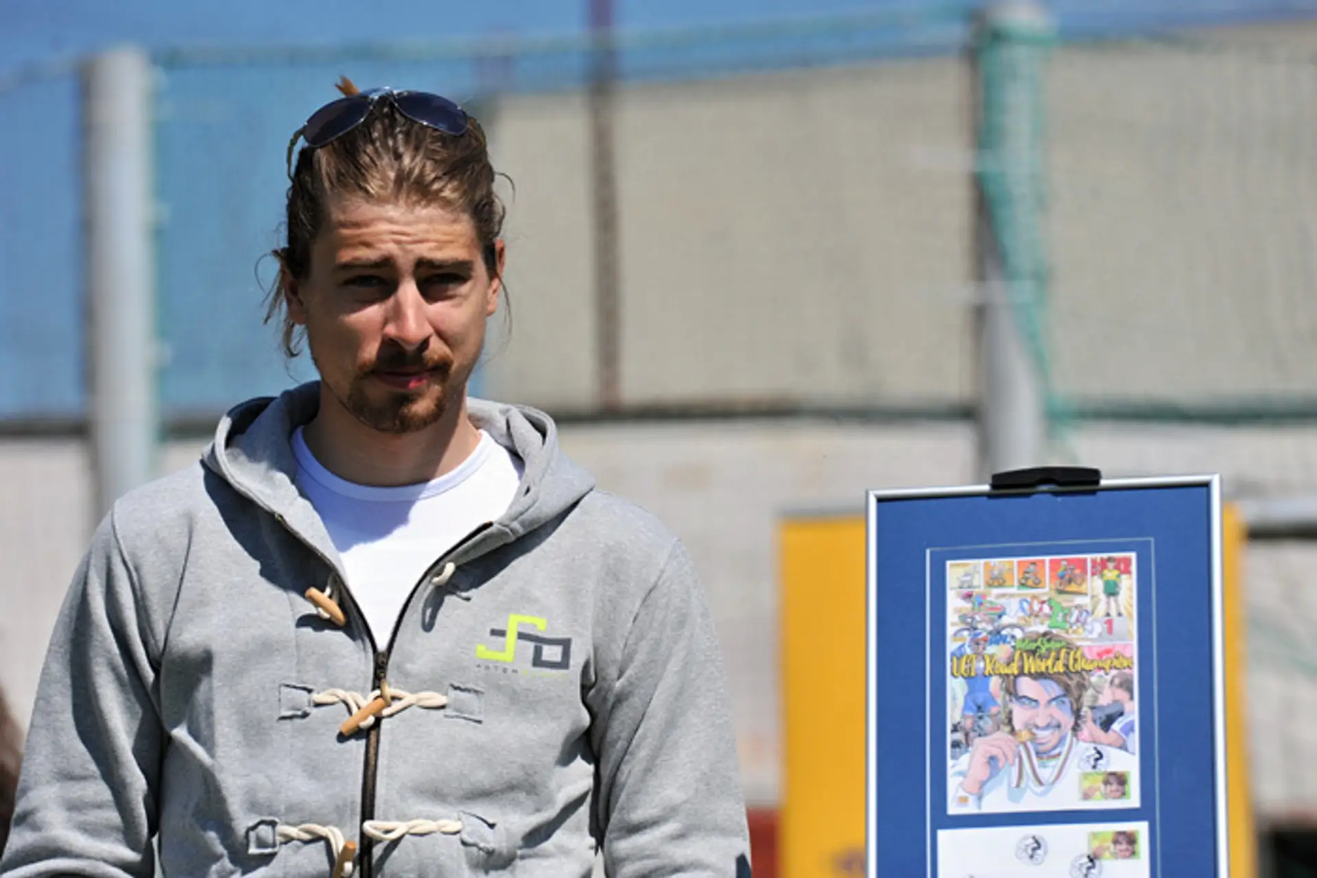 Majster sveta v cestnej cyklistike Peter Sagan pózuje pri nálepnom liste s novou známkou a obálkou s pečiatkou.
