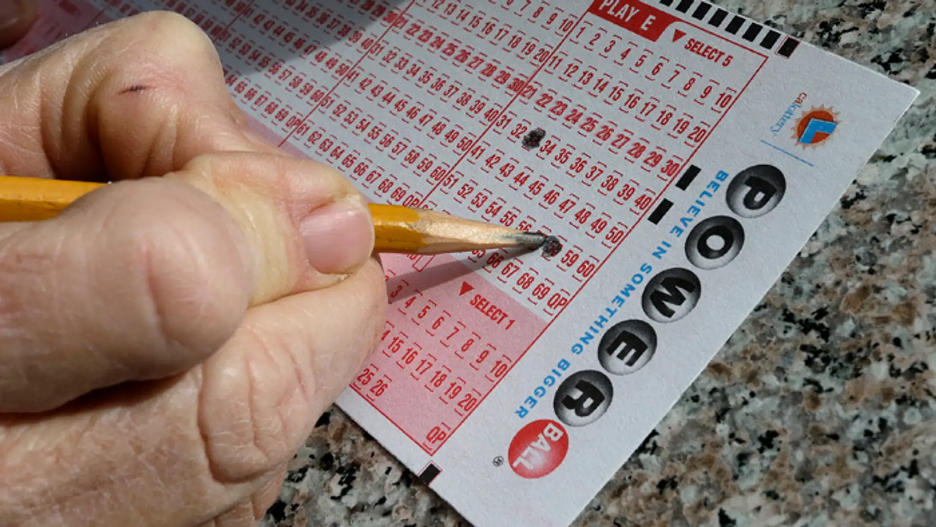 Tipujúci zaškrtáva čísla v americkej lotérii Powerball.