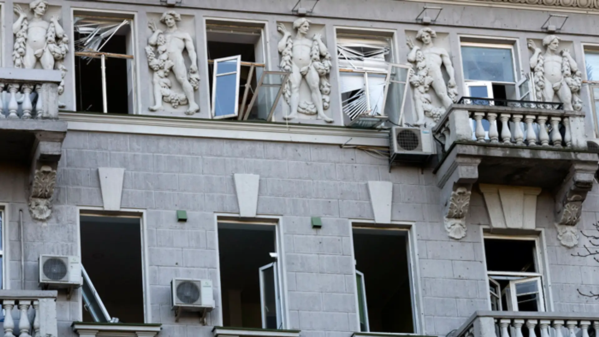 Rozbité sklá na oknách historickej budovy po ruskom raketovom útoku v Kyjeve.