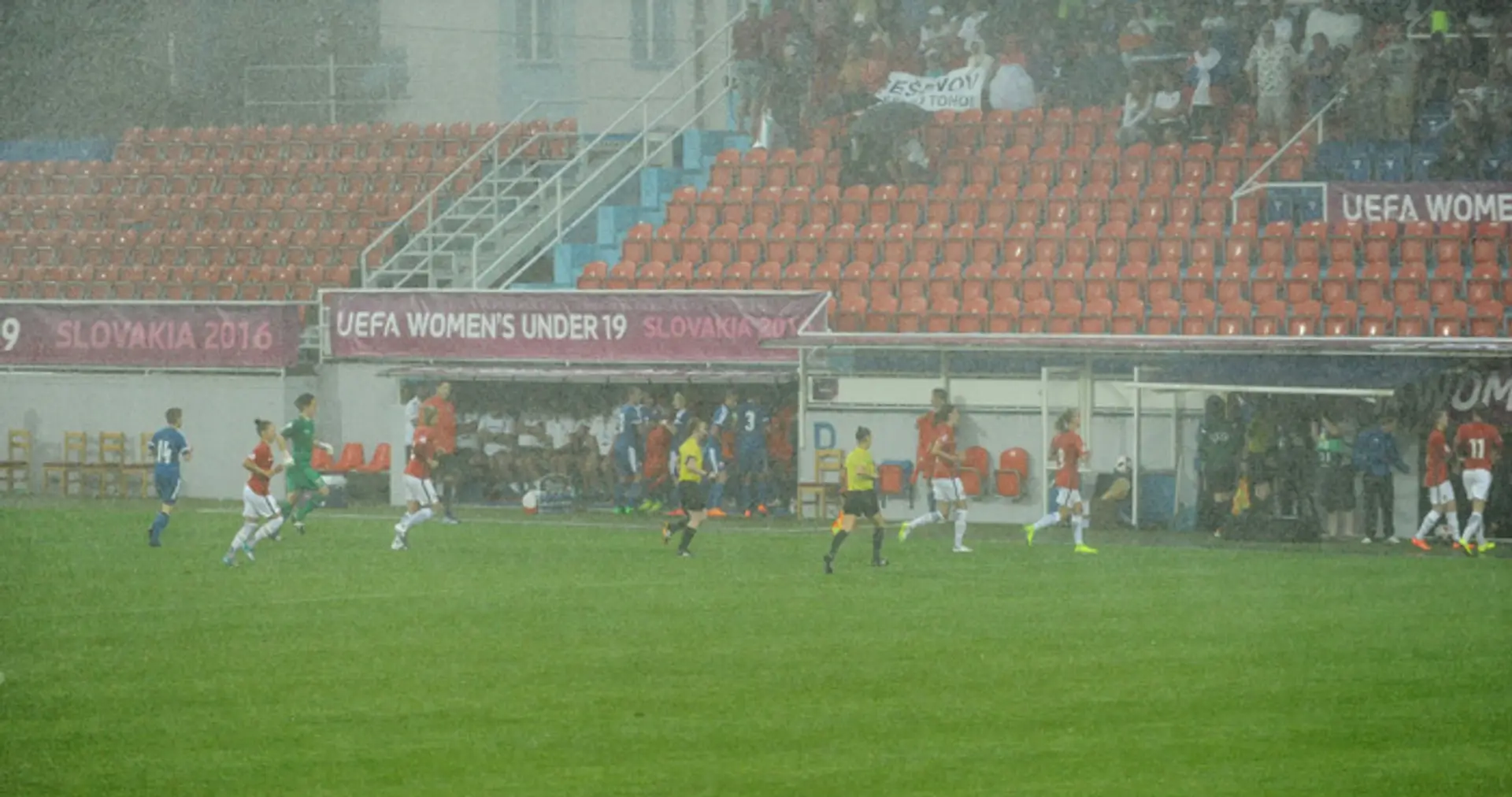 Futbalistky Nórska (červené dresy) a Slovenska (modré dresy) počas silného lejaku v zápase základnej A-skupiny futbalových ME 19
