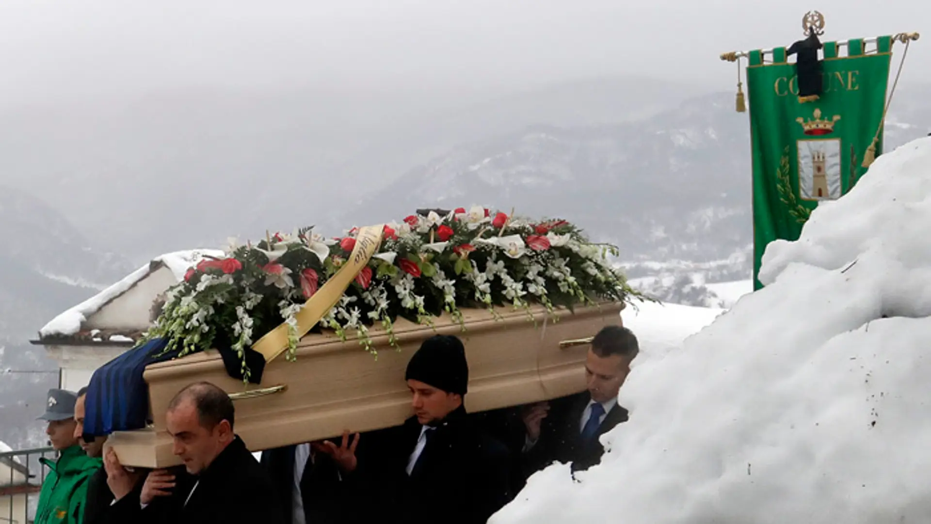 Ľudia nesú truhlu s pozostatkami Alessandra Giancaterina, jednej z obetí z hotela zasypaného lavínou.