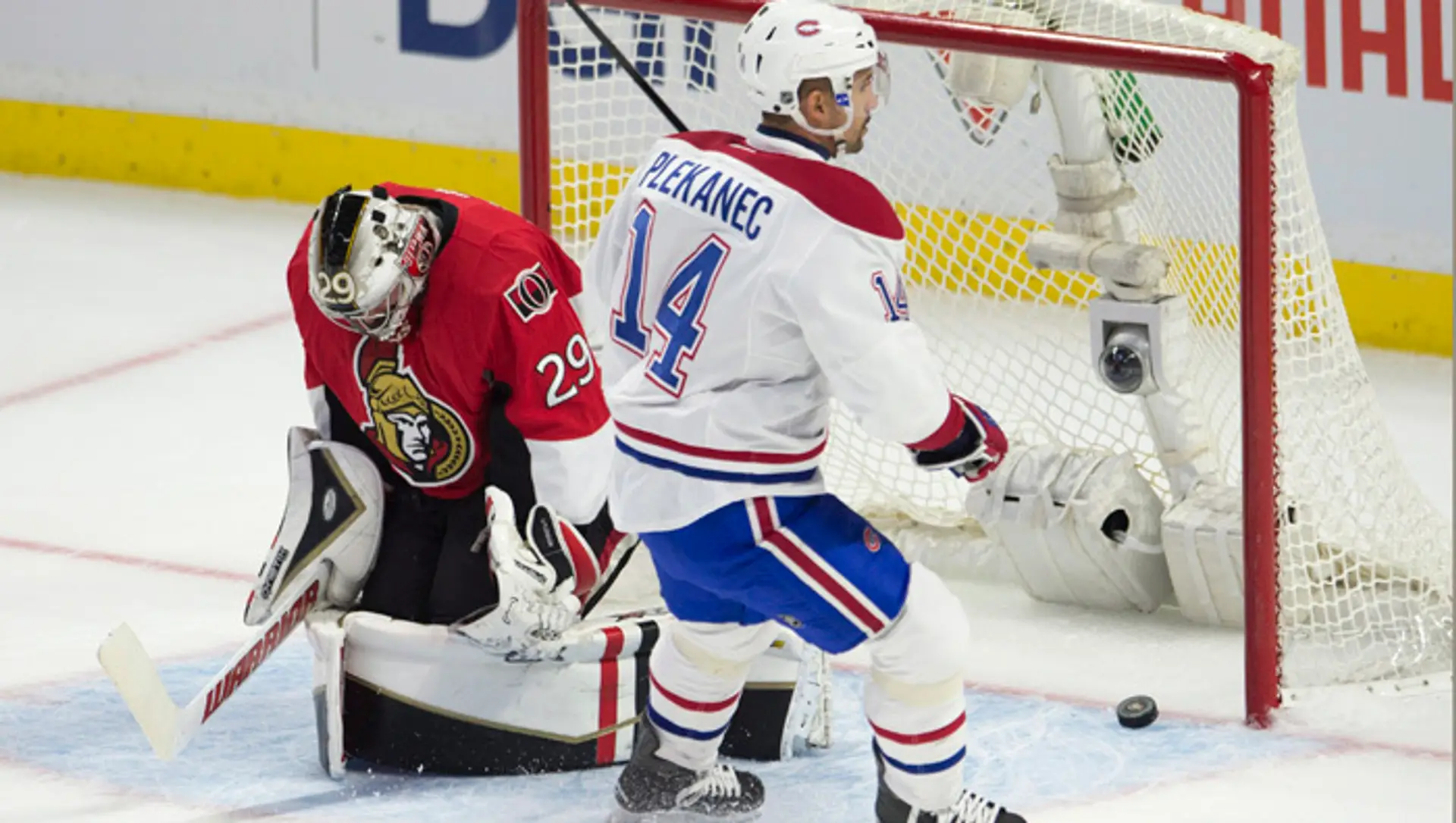 Hokejista Montrealu Canadiens Čech Tomáš Plekanec prekonáva brankára Ottawy Senators Matta O'Connora v zápase zámorskej hokejove
