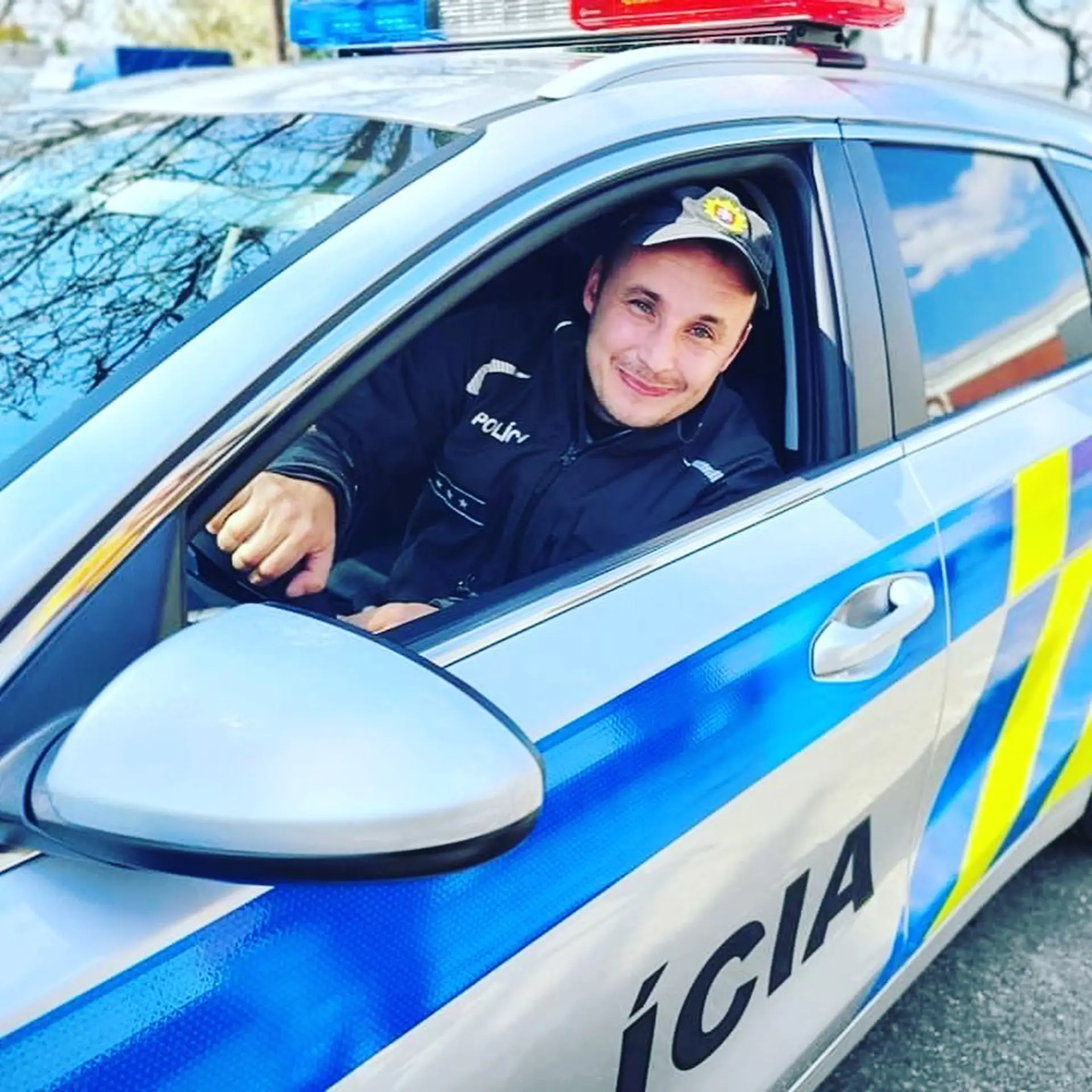 Policajt sedí v novom policajtom aute.
