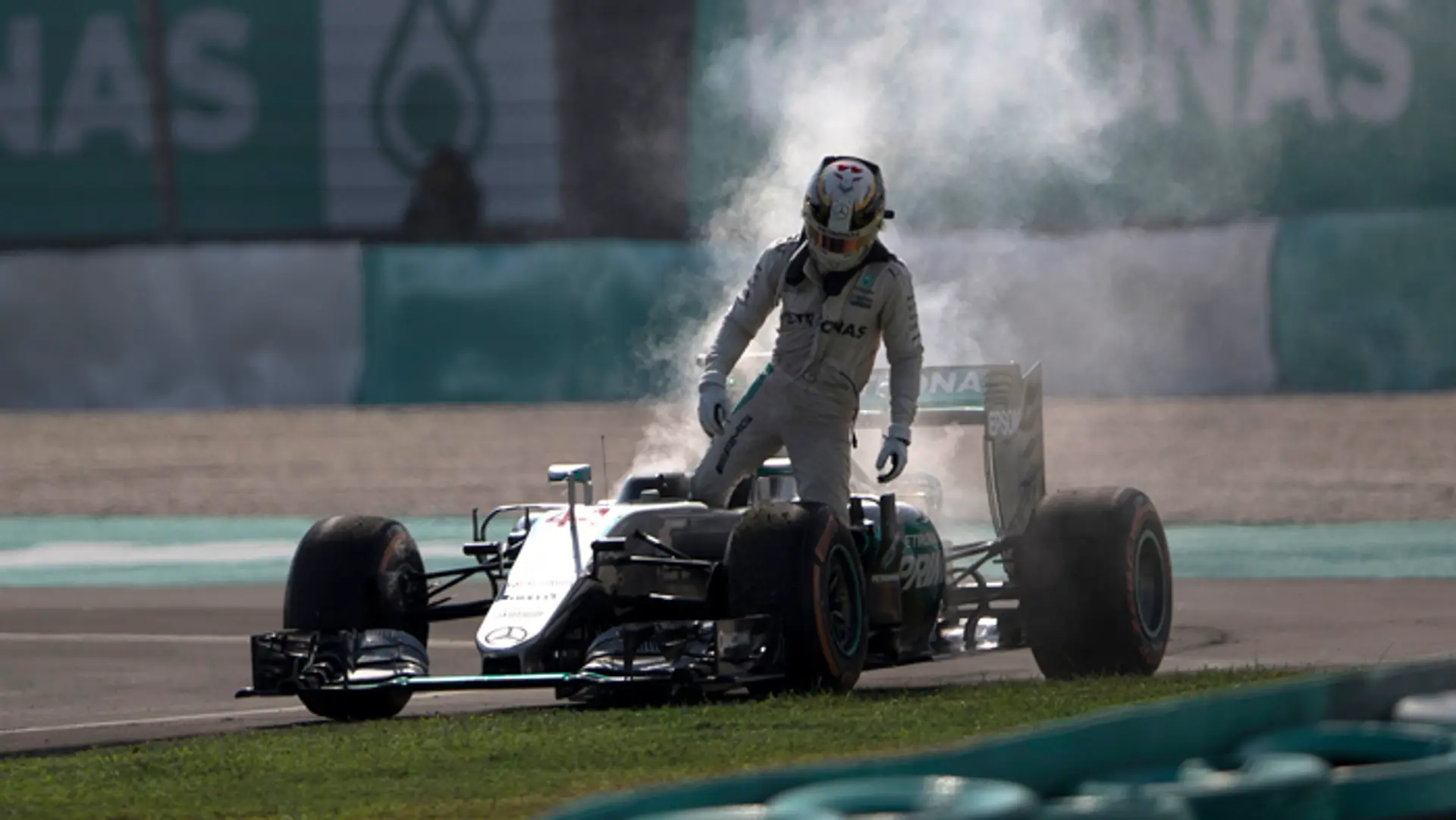Lewis Hamilton opúšťa dymiaci monopost po poruche motora počas VC Malajzie .