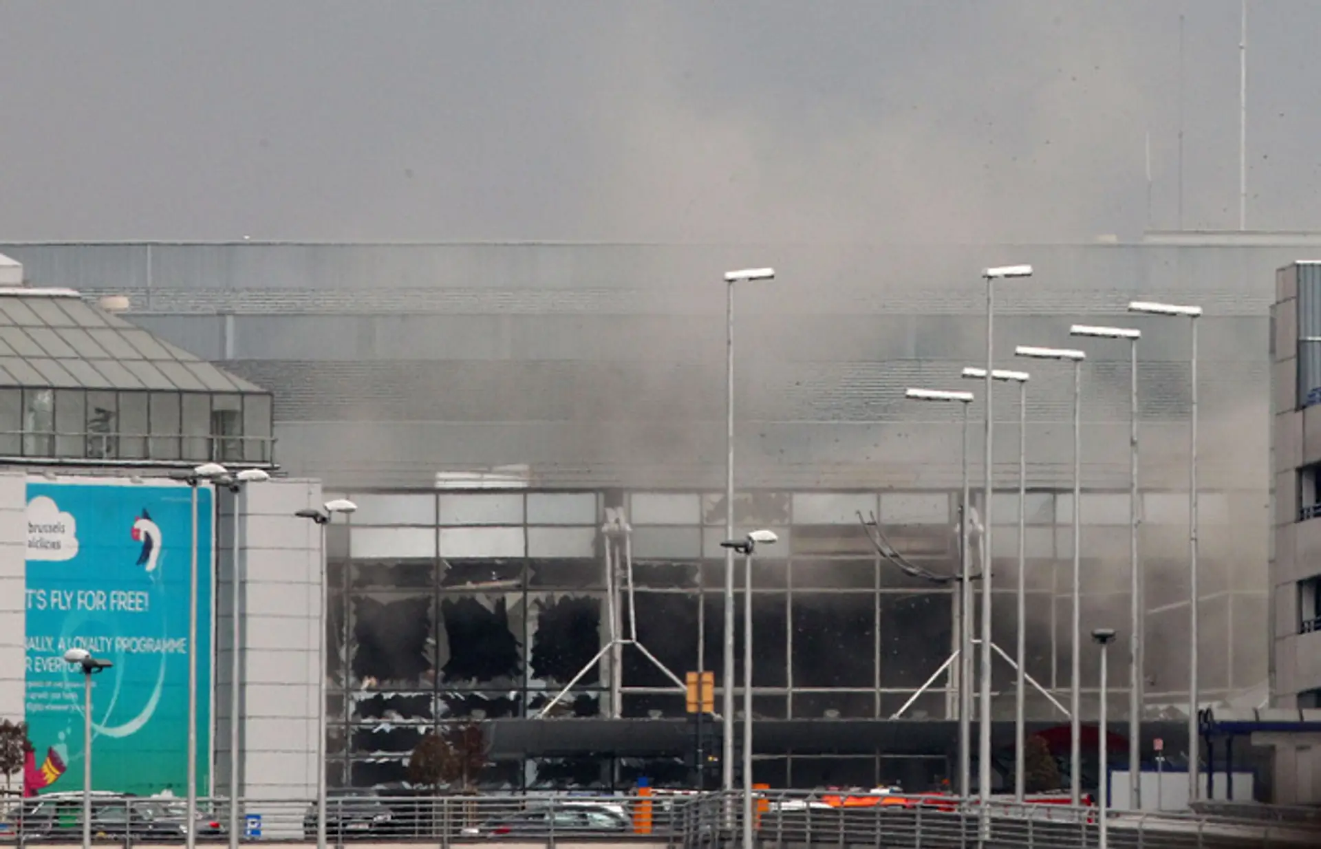 Dym stúpa z letiska Zaventem po riadenom výbuchu v Bruseli.