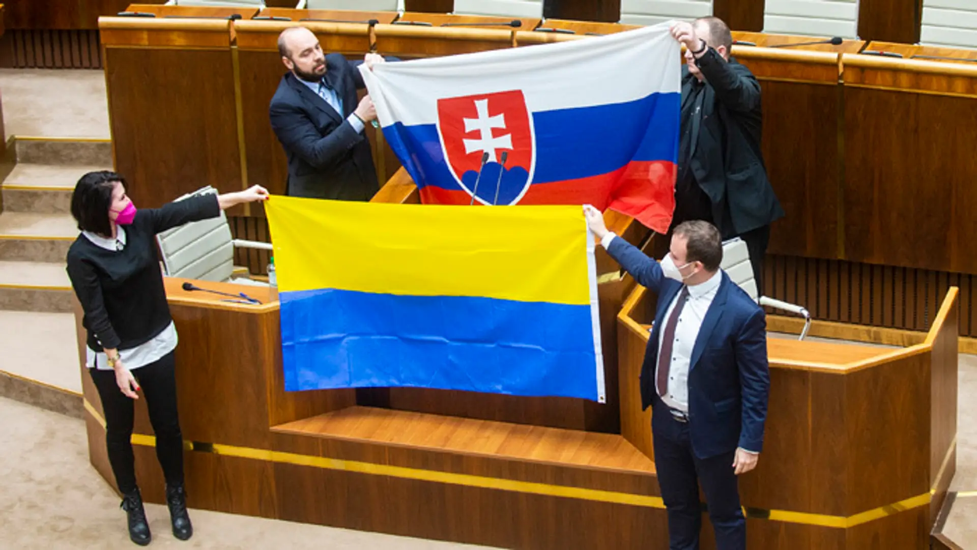 Zľava Andrej Medvecký, Peter Krupa (obidvaja ĽSNS) držia slovenskú vlajku a dole Jana Bittó Cigániková a Miroslav Žiak (obidvaja