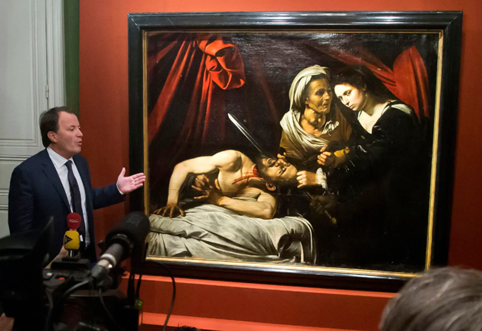 Aukčný úradník Marc Labarbe prezentuje nájdený obraz, ktorého autorom by mohol byť Caravaggio.