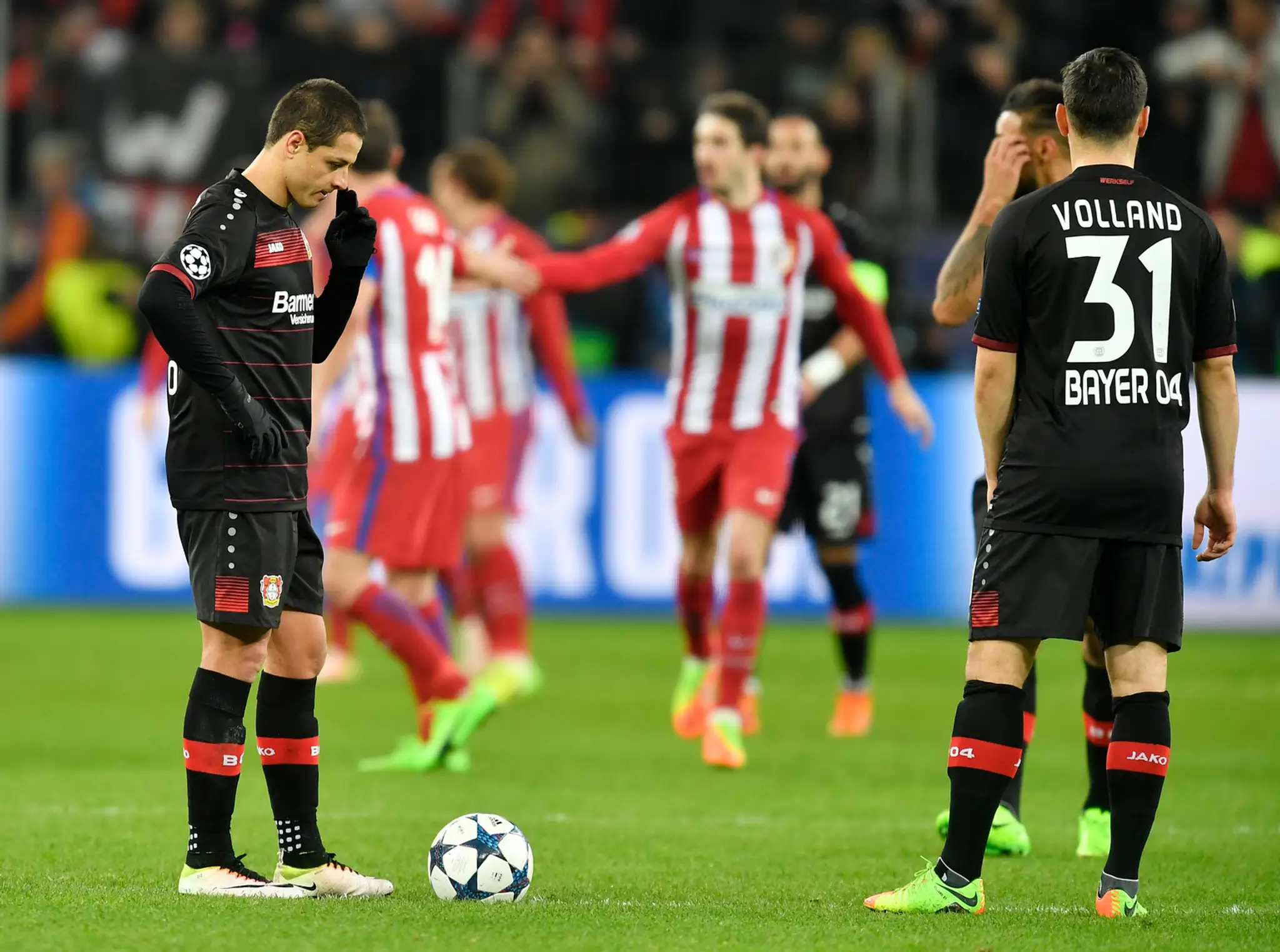 Chicharito (vľavo) z Leverkusenu čaká na rozohratie po inkasovanom góle proti Atléticu v osemfinále LM.