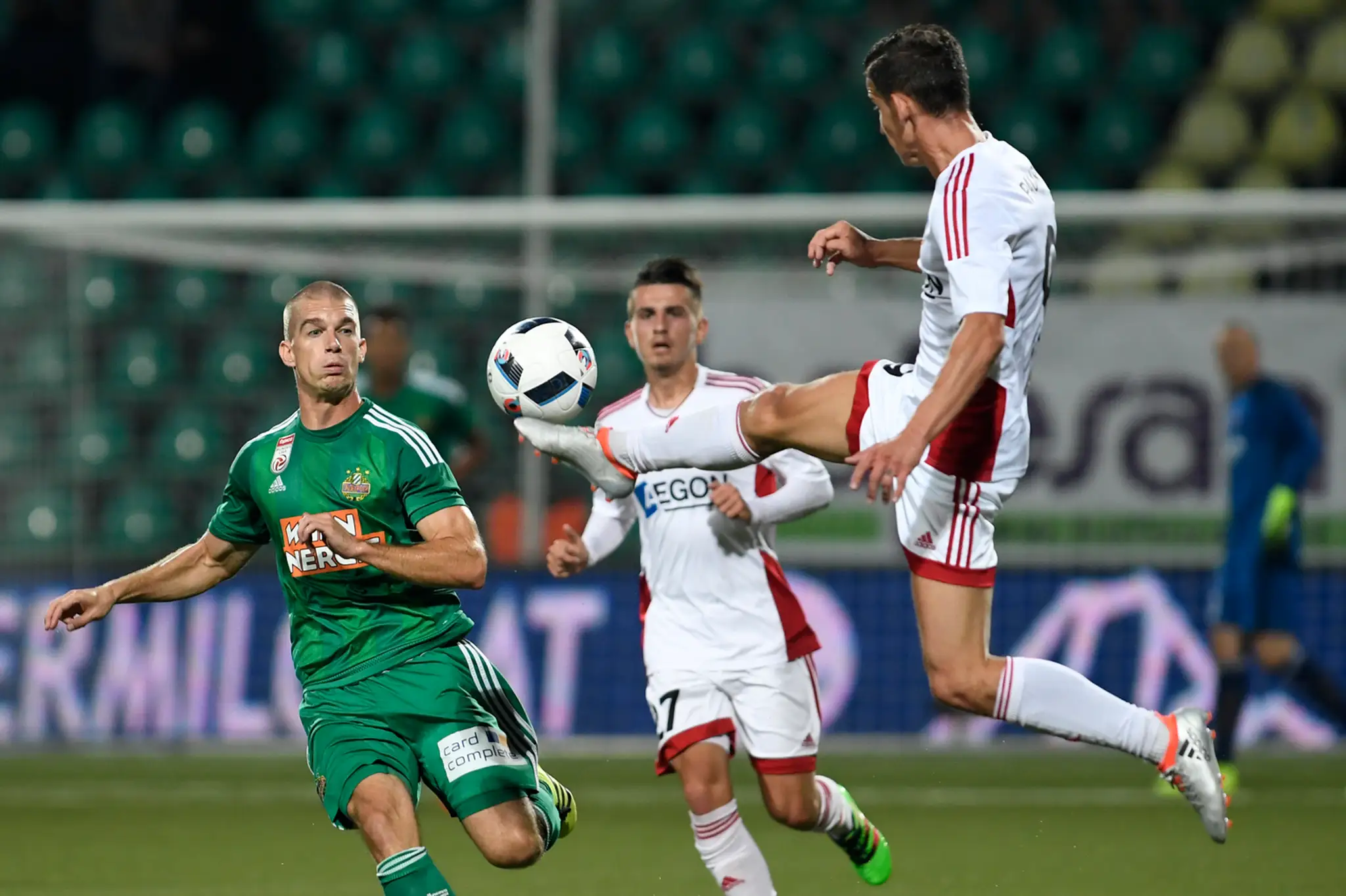 O loptu bojujúci útočník Rapidu Viedeň Louis Schaub proti dvojici Trenčanov Denis Jančo a Jakub Paur (vpravo).