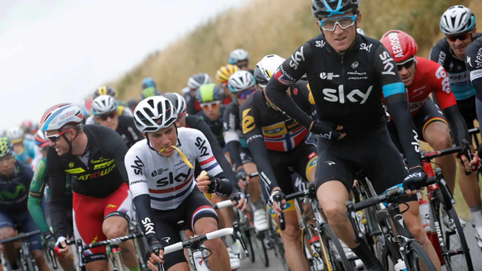 Peter Kennaugh počas etapy si pochutnal na banáne, vpravo pred ním Geraint Thomas.