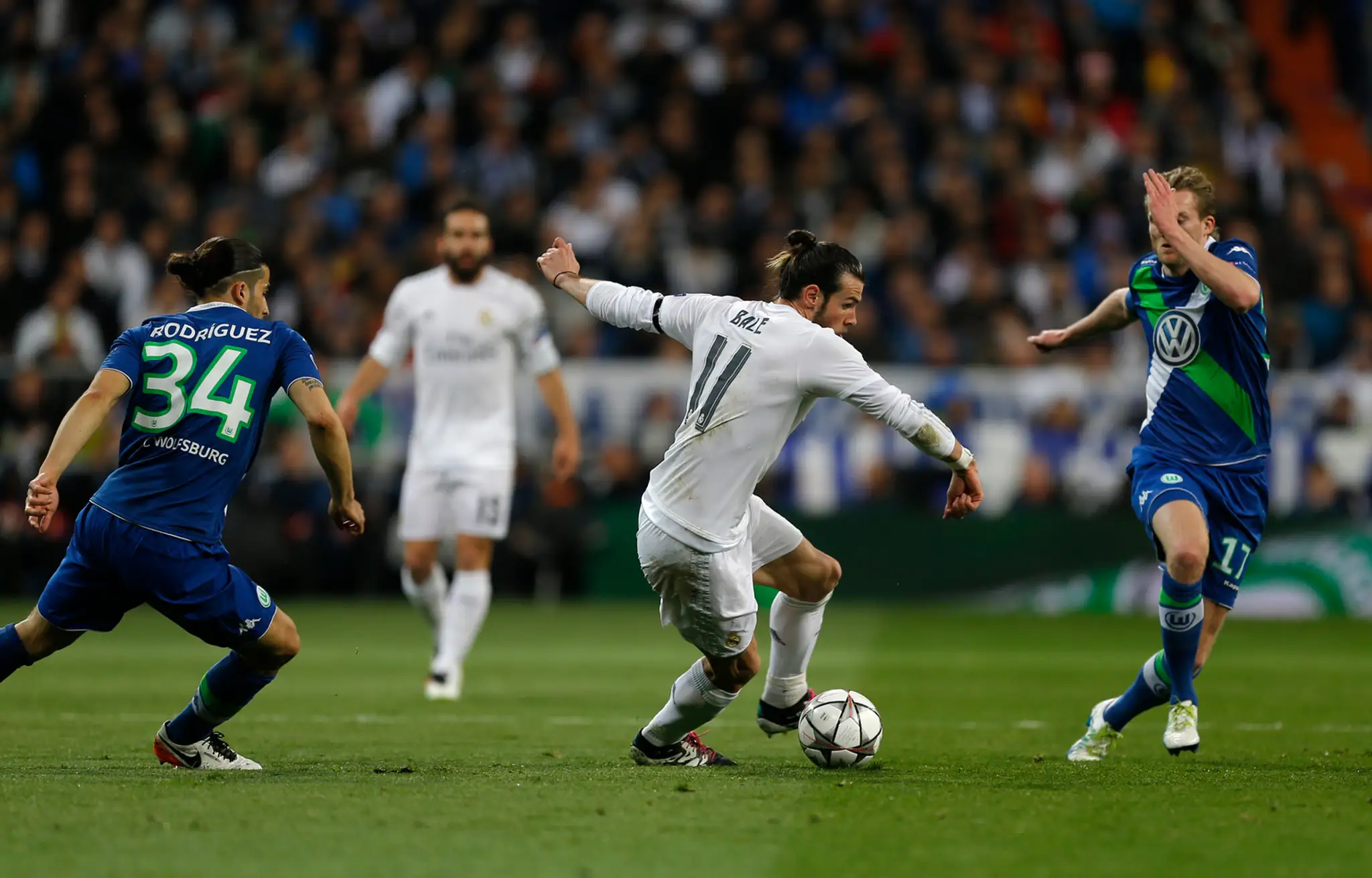 Gareth Bale z Realu Madrid v obkľúčení dvoch protihráčov Wolfsburgu v odvetnom dueli štvrťfinále Ligy majstrov.