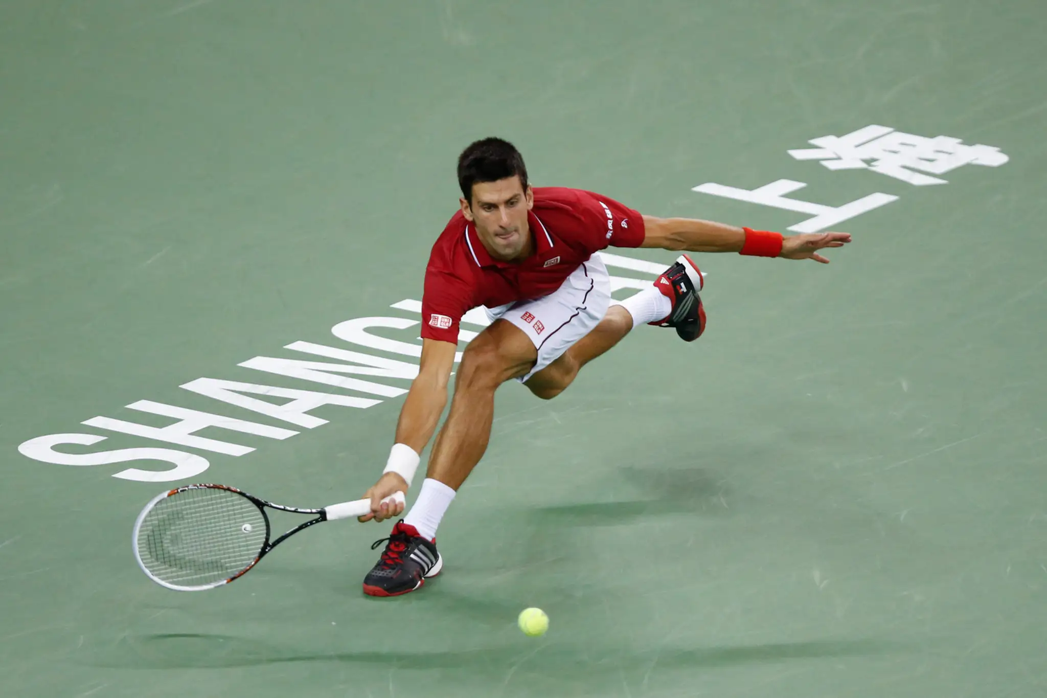 Novak Djokovič odvracia loptičku v semifinálovom zápase v Šanghaji proti Rogerovi Federerovi.