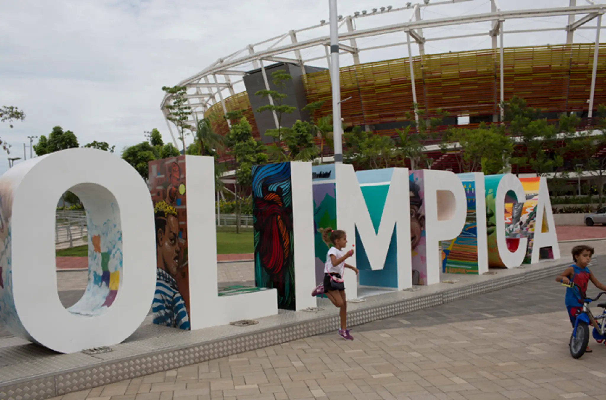 Deti sa hrajú vedľa nápisu Olimpica v Olympijskom parku v brazílskom Riu. 