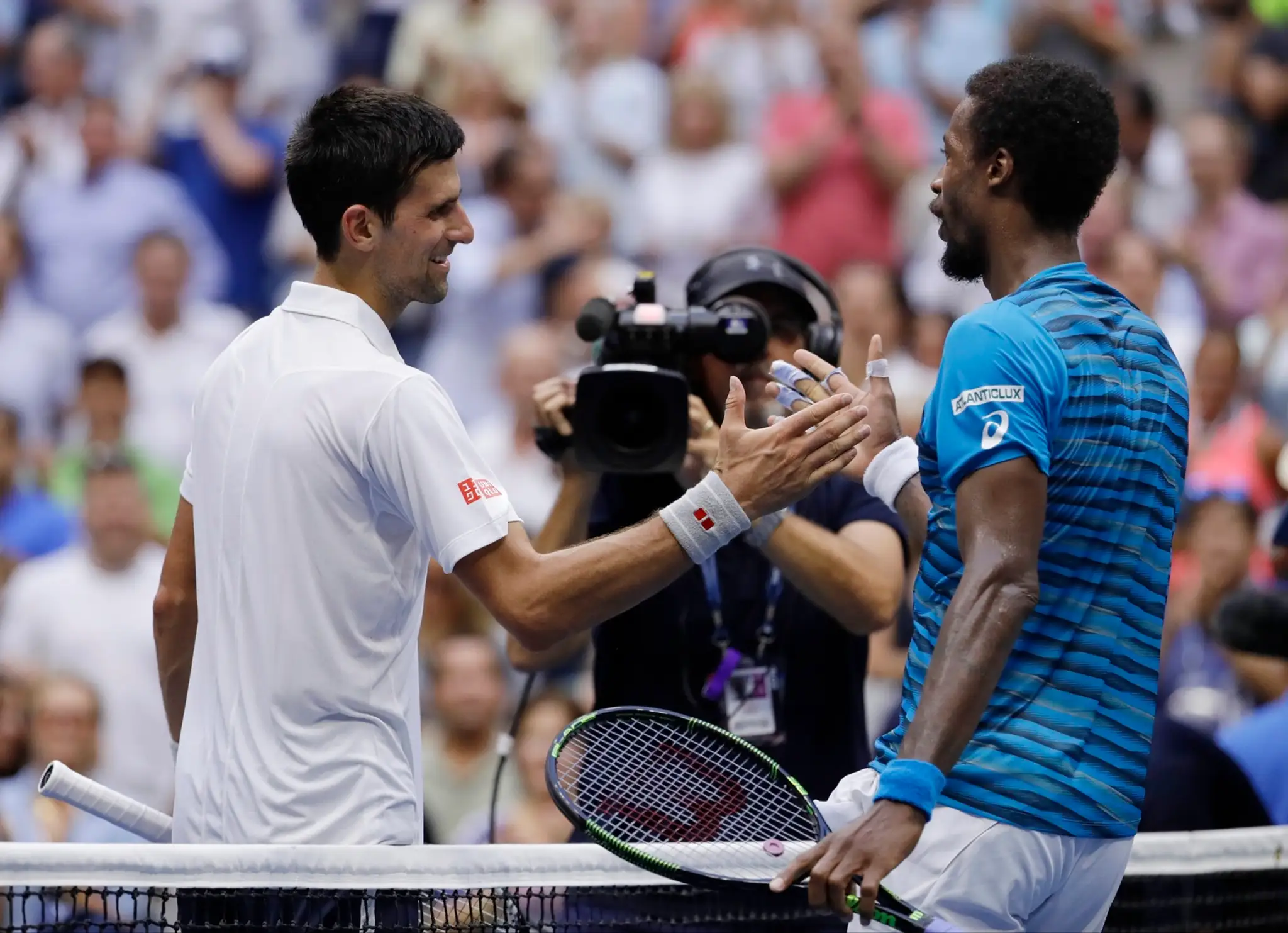 Novak Djokovič a Gael Monfils si podávajú ruky po semifinálovom zápase na US Open.