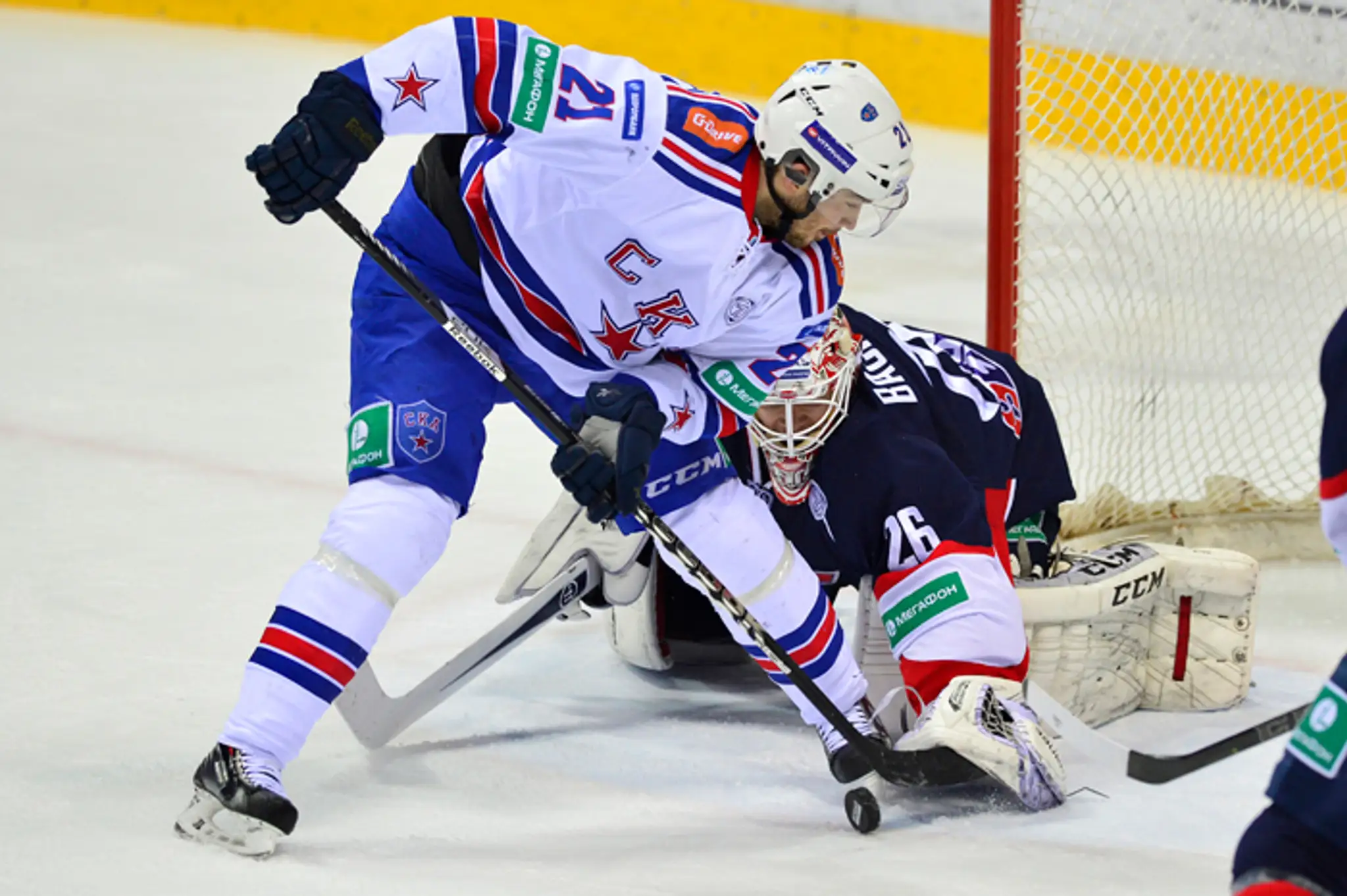 Jimmie Ericsson (SKA) a (vpravo) chytá puk brankár Slovana Johan Backlund (Slovan)