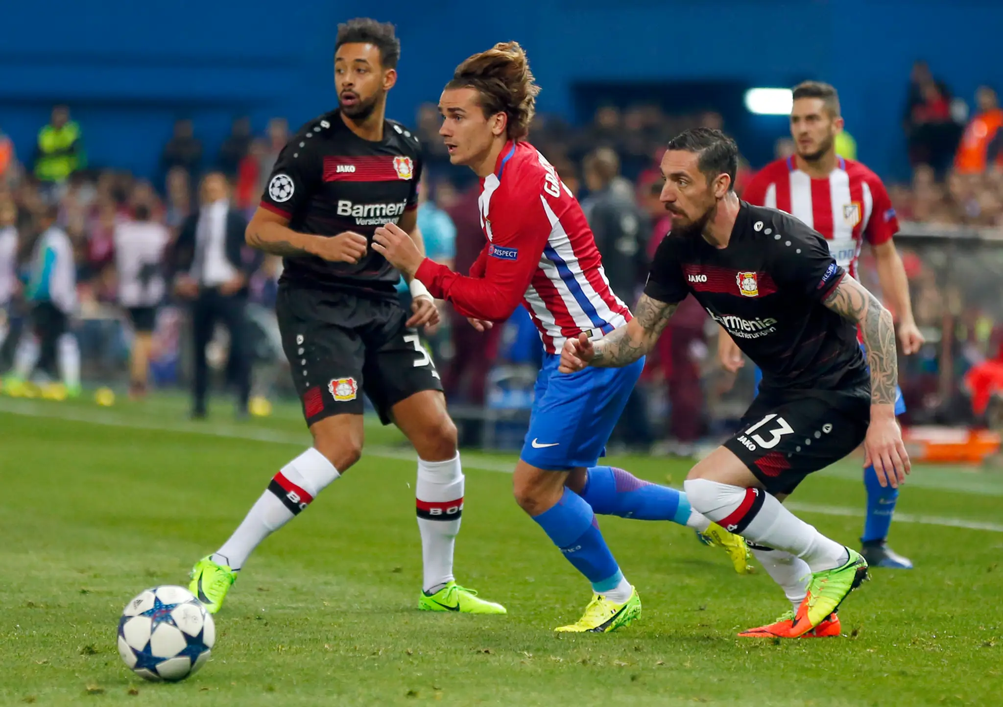 Roberto Hilbert (vpravo) z Leverkusenu stíha strelca Atlética Antoina Griezmanna v odvete osemfinále LM.