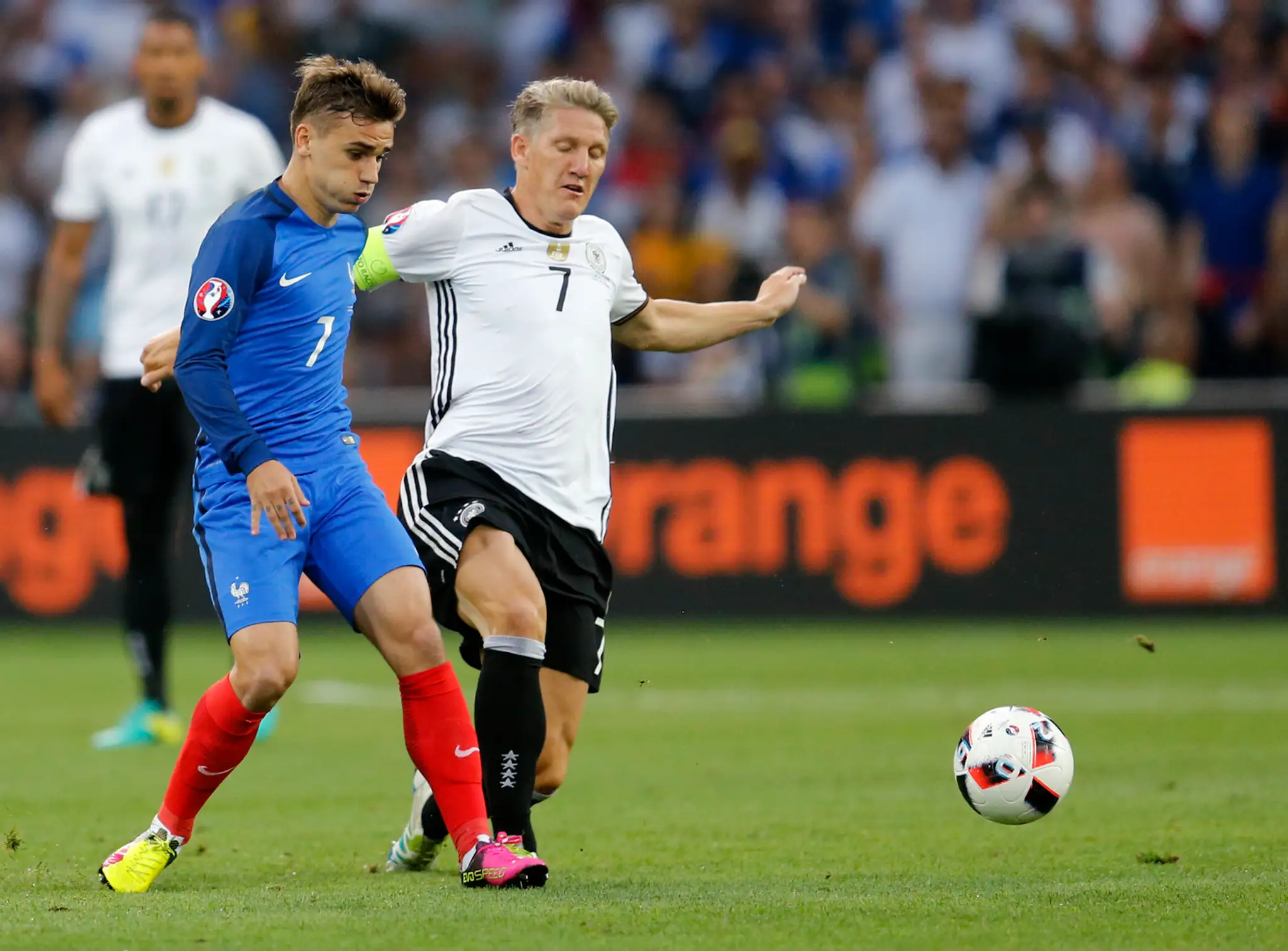 Francúzsky snajper Antoine Griezmann (vľavo) a Nemec Bastian Schweinsteiger v súboji počas semifinále ME.