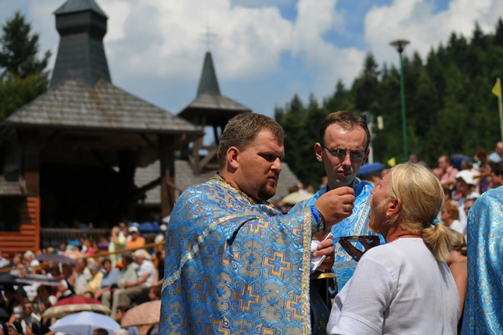 Kňazi dávajú pútnikom sväté prijímanie počas archijerejskej svätej liturgie s myrovaní na hlavnej púti na horu Zvir.