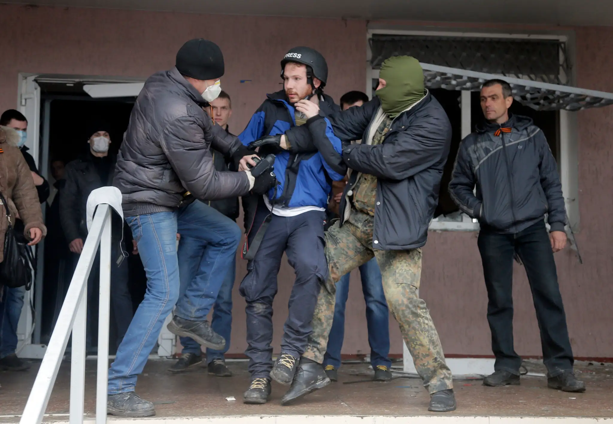 Maskovaní proruskí aktivisti útočia na britského fotografa Fredericka Paxtona počas útoku na policajnú stanicu v ukrajinskom mes