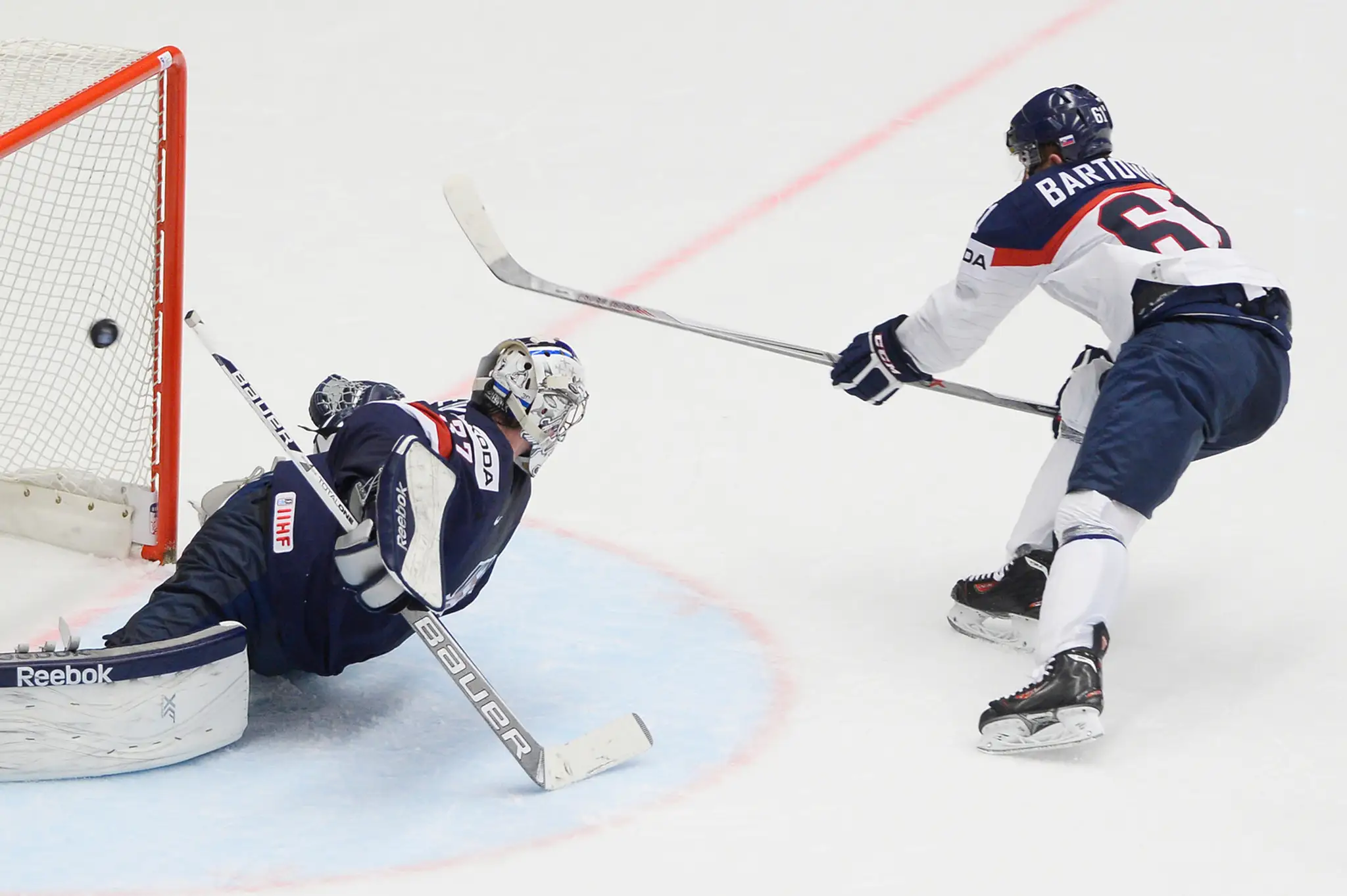 Zprava Milan Bartovič (Slovensko) a brankár Connor Hellebuyck 