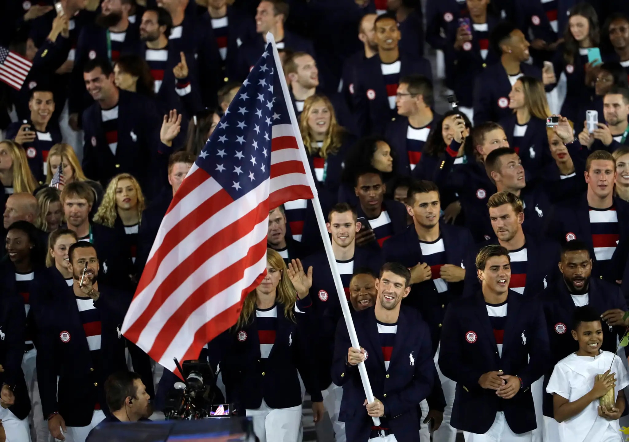 Fenomenálny a dnes už legendárny plavec Michael Phelps nesie americkú vlajku na otváracom ceremoniáli OH v Riu.