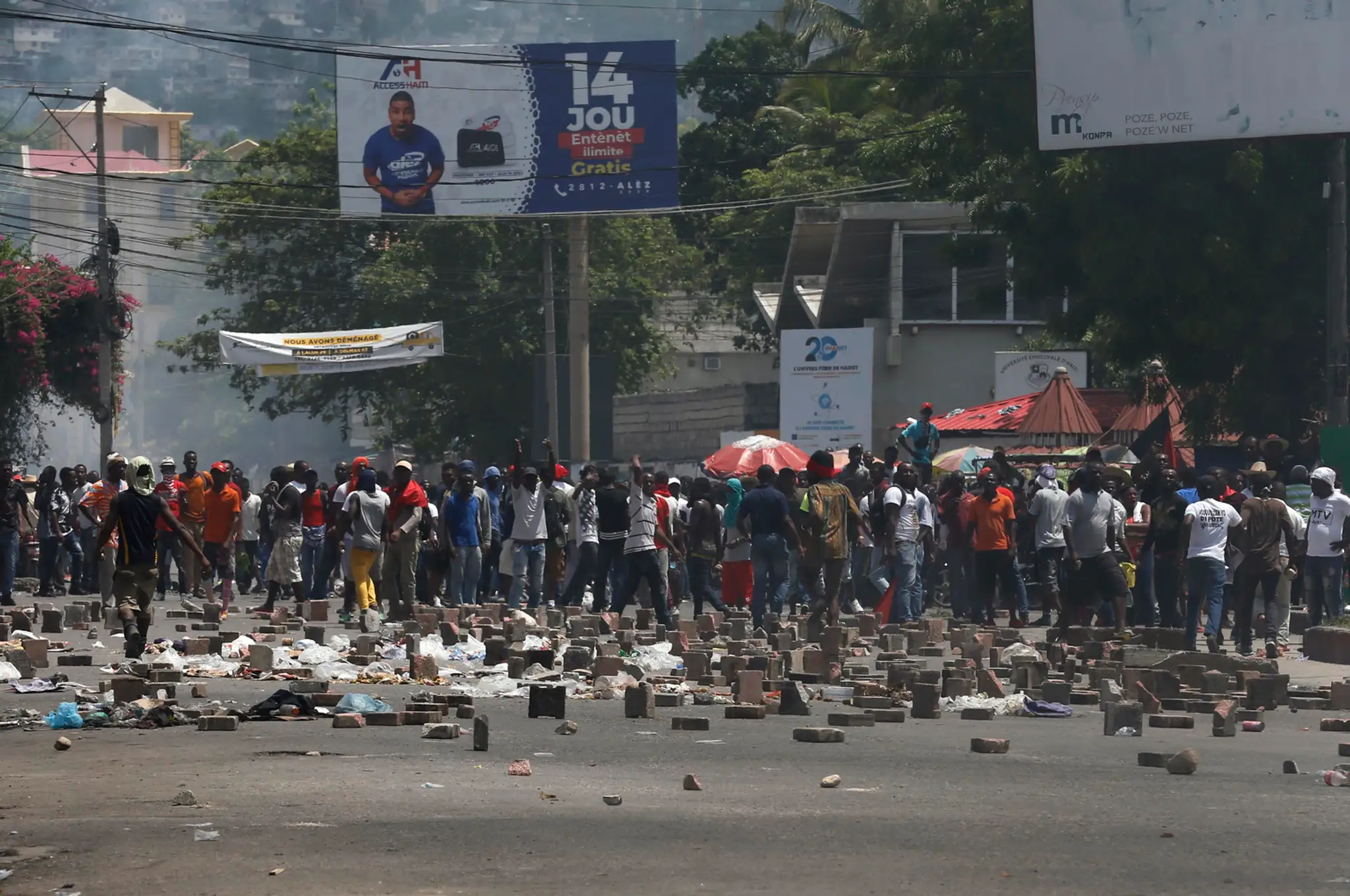 Ľudia odvážajú zraneného počas protestov na Haiti.