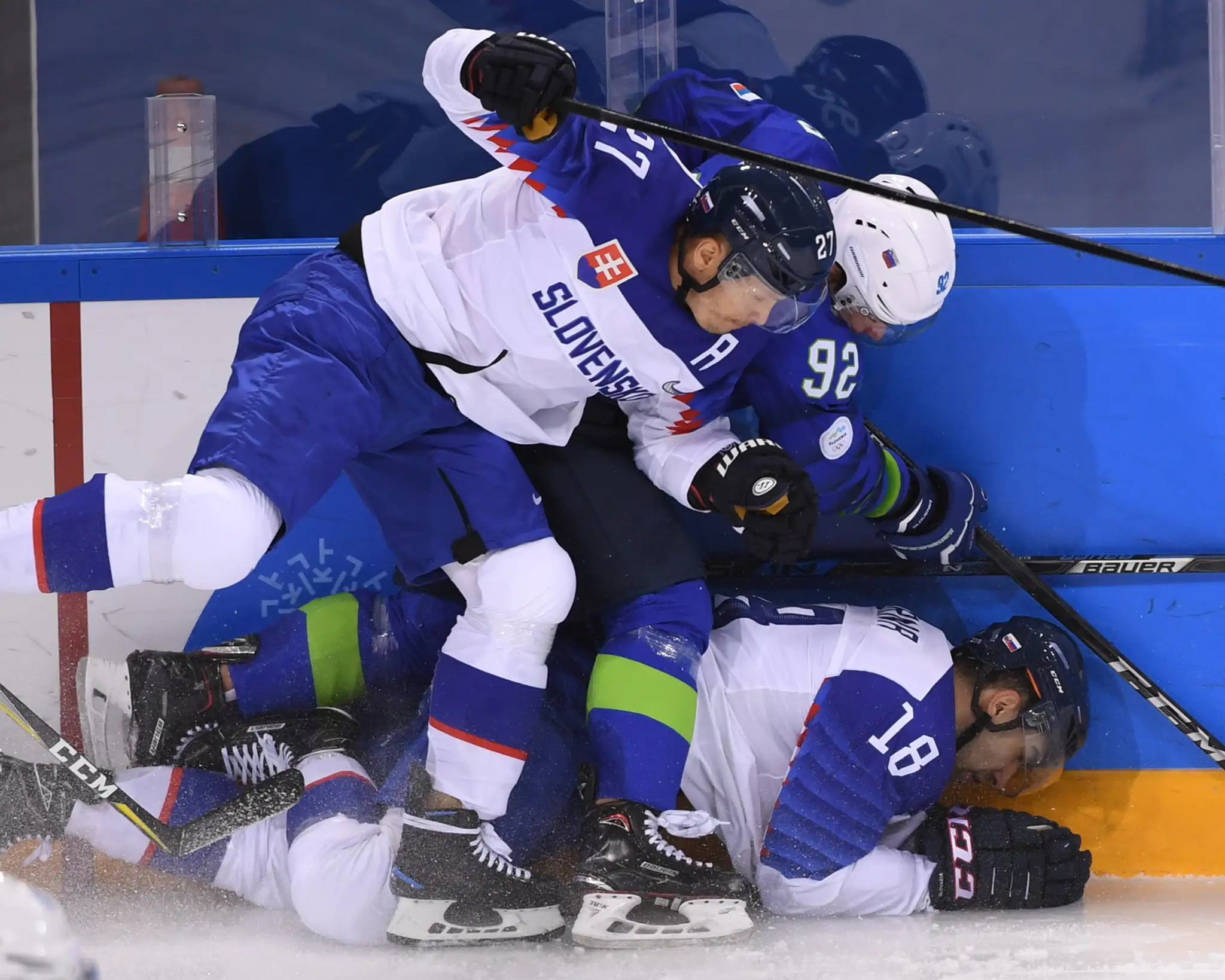 Slovák Michal Čajkovský (vľavo) a Slovinec Žiga Jeglič bojujú o puk v zápase na ZOH 2018.