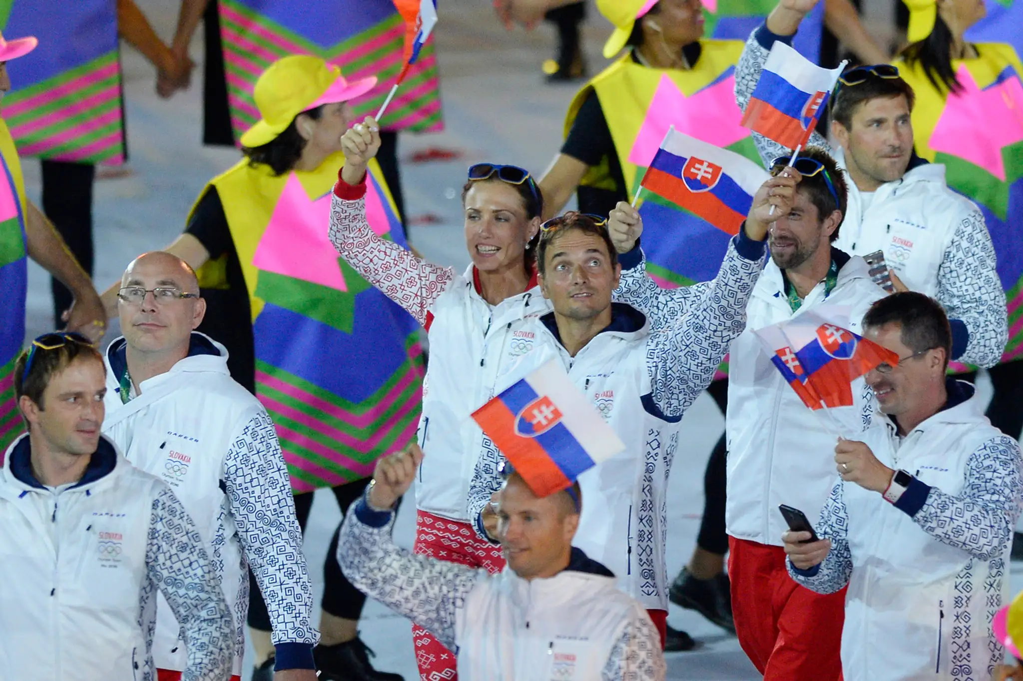 S vlajočkami mávajúci členovia slovenskej výpravy na otváracom ceremoniáli OH v Riu.