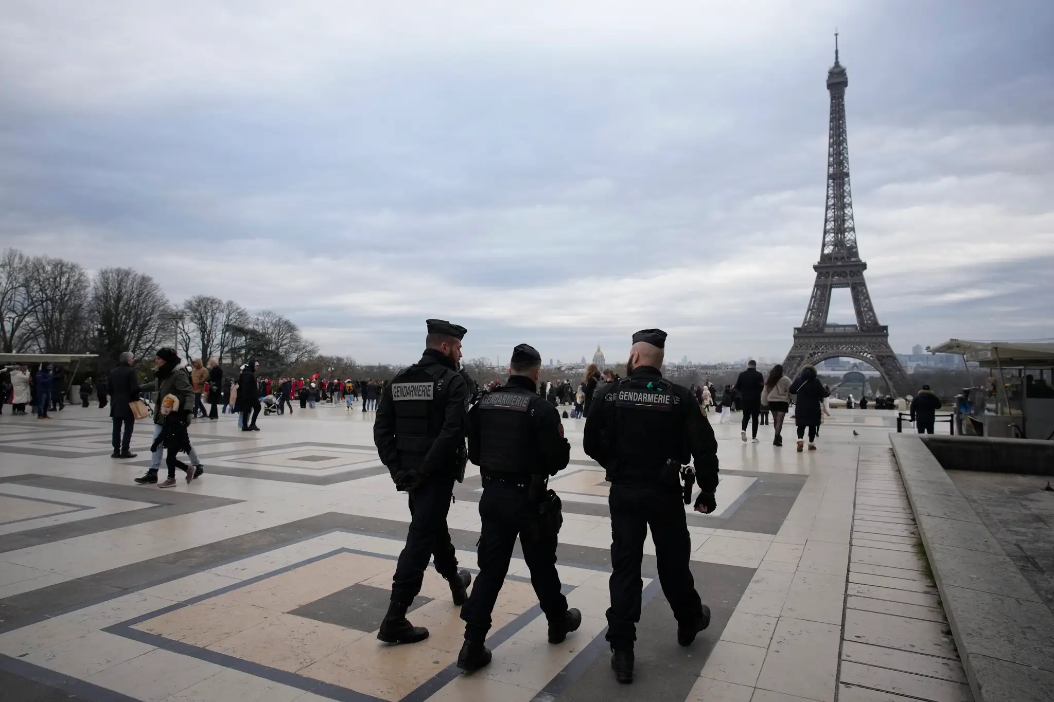 Policajti  hliadkujú neďaleko Eiffelovej veže v Paríži v nedeľu 3. decembra 2023.