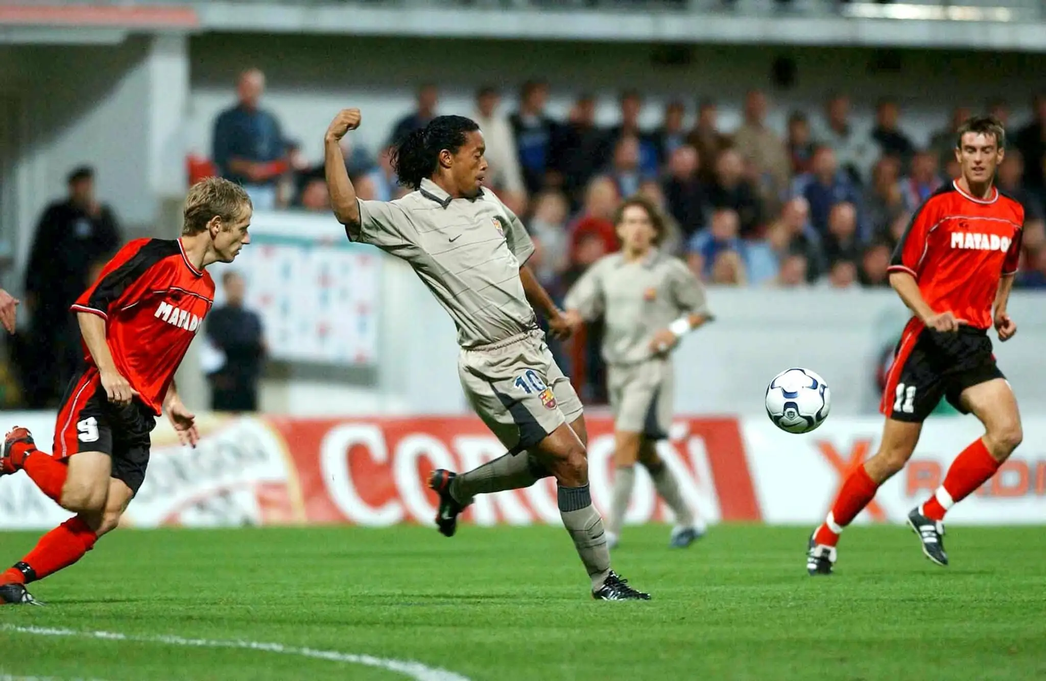 Ronaldinho uprostred bojuje o loptu s Ivanom Belákom vľavo a Milanom Jamborom.