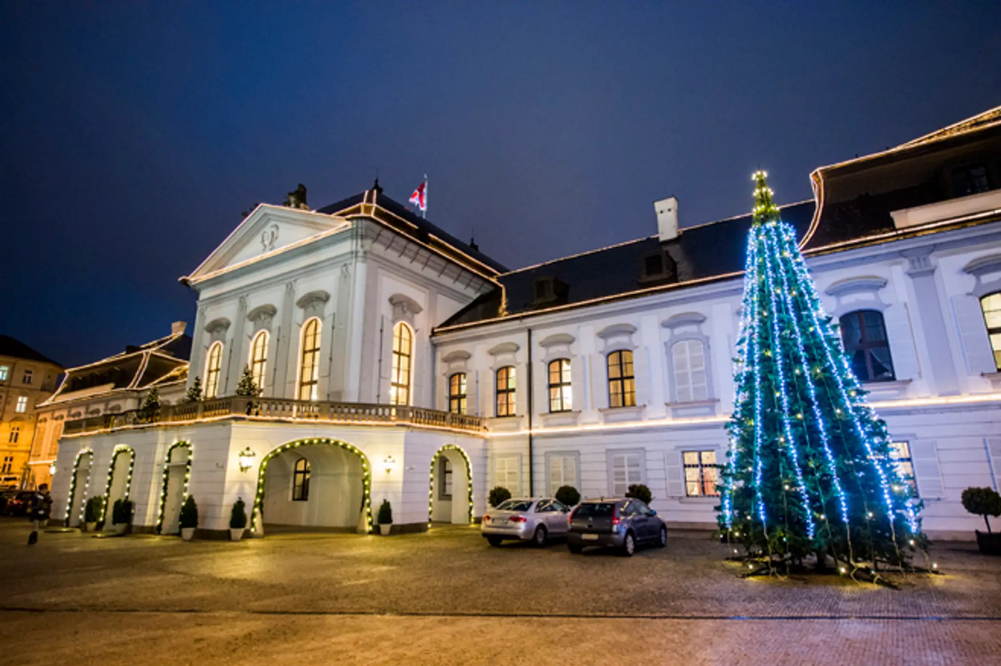 Rozsvietená vianočná výzdoba a stromček na prednom nádvorí Prezidentského paláca.