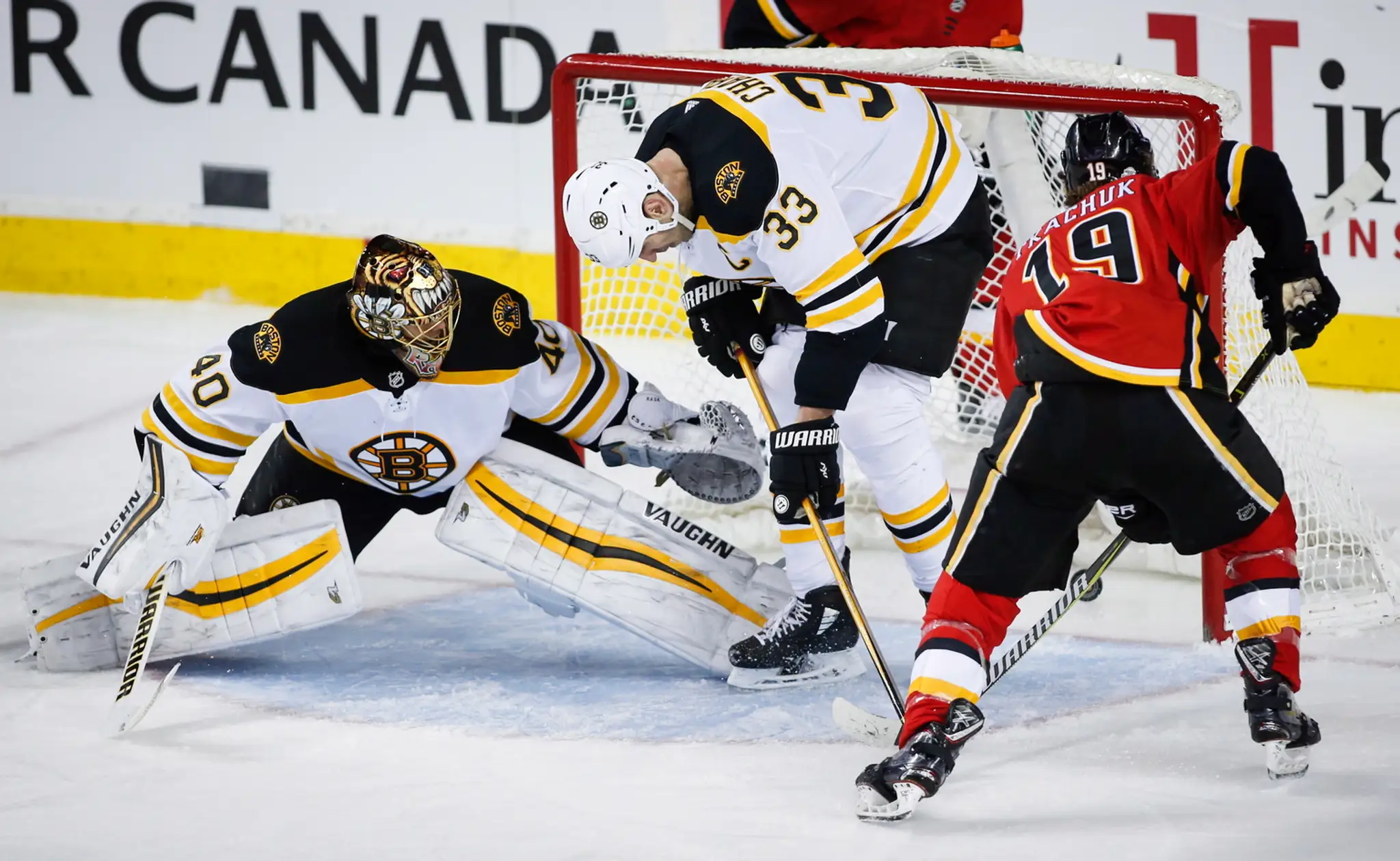 Kapitán Bostonu Zdeno Chára bojuje o puk s Matthewom Tkachukom (vpravo) z Calgary.