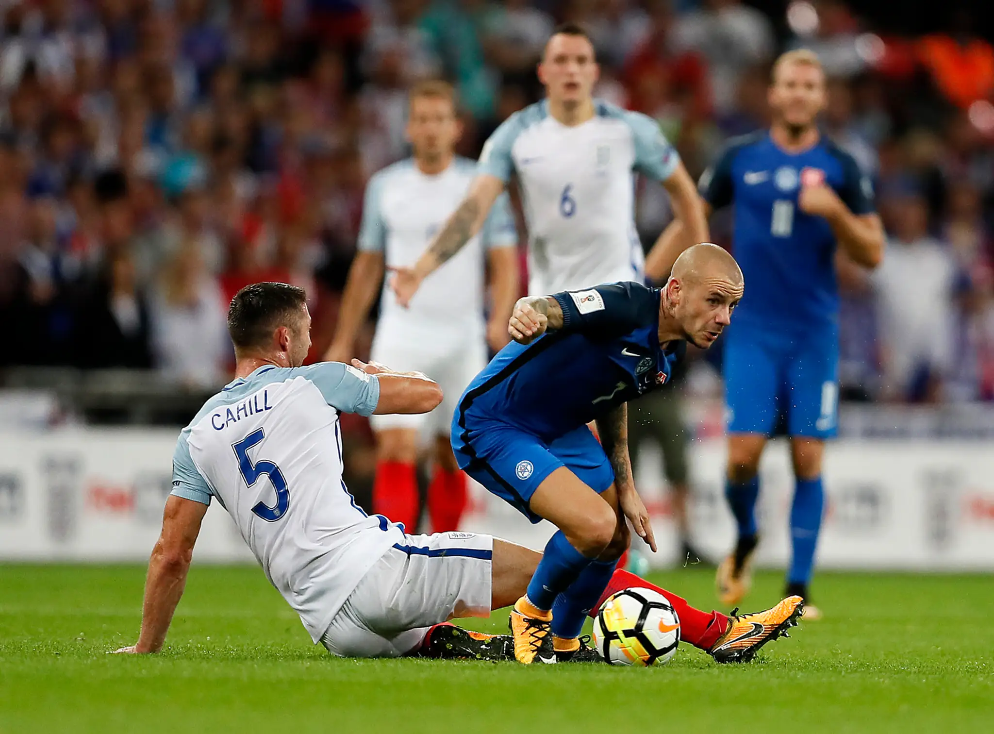 Gary Cahill (vľavo) bojuje o loptu s Vladom Weissom v kvalifikácii MS proti Anglicku.