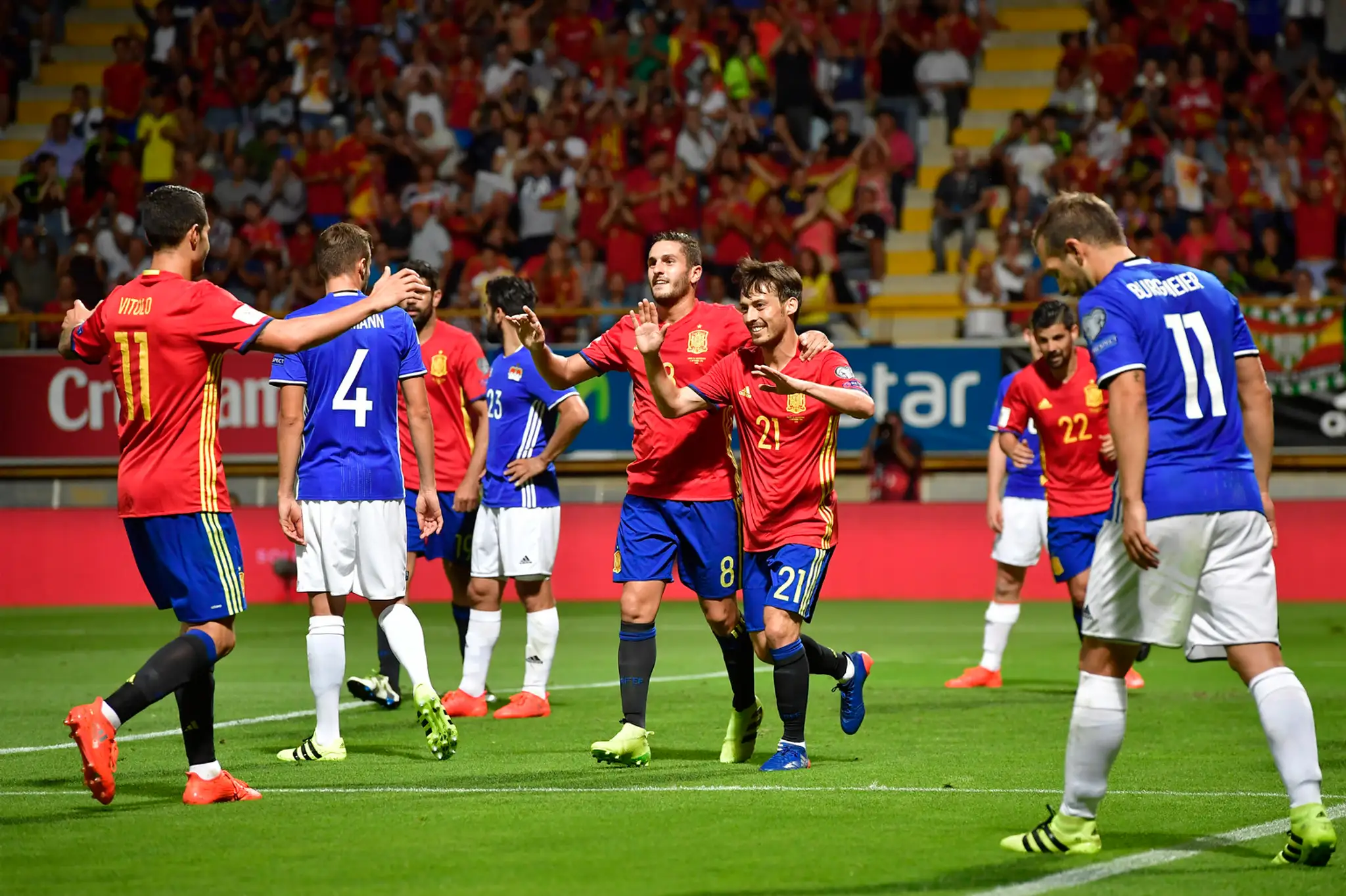 David Silva (v strede menší v červenom) soalvuje so španielskymi spoluhráčmi kvalifikačný gól proti Lichtenštajnsku.